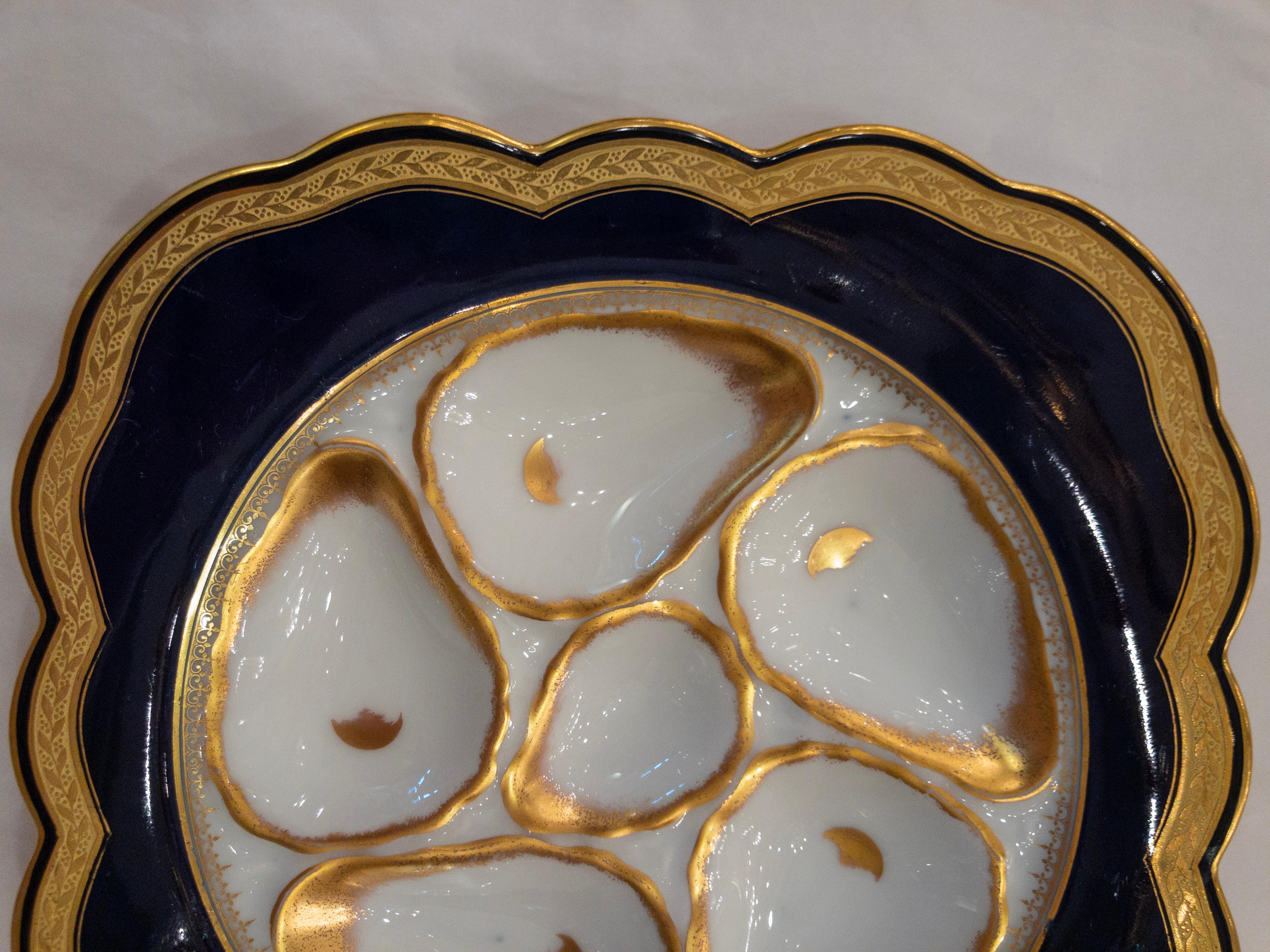 Antique German porcelain oyster plate in rare cobalt color with white oyster wells and gold trim, circa 1890s.