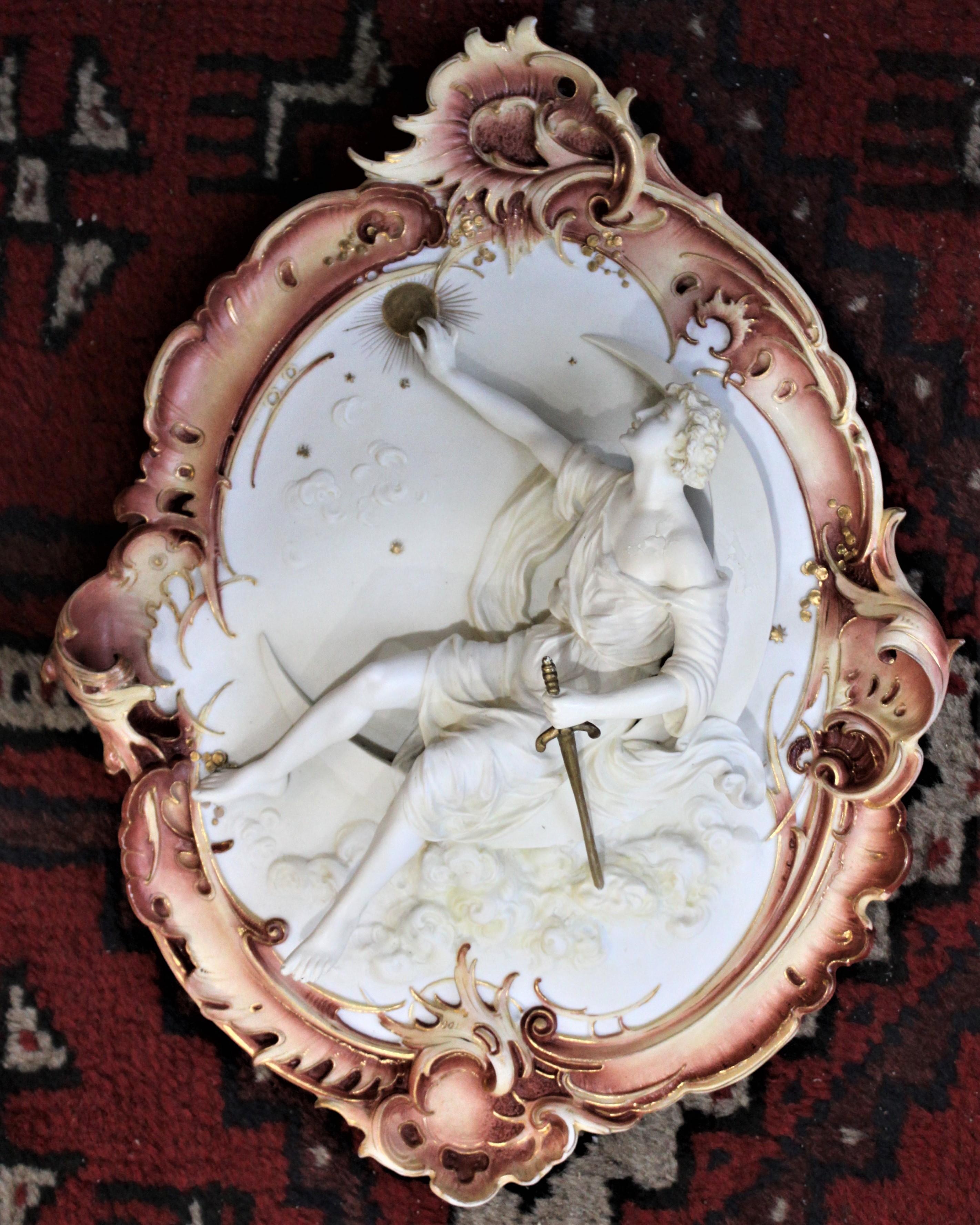 This antique wall plaque was made by the Royal Berlin Porcelain Factory in the early 1800s in an Ancient Greek Revival style. The plaque depicts a metaphorical interpretation of Helios, the God of The Sun. Helios is represented as a reclining robed