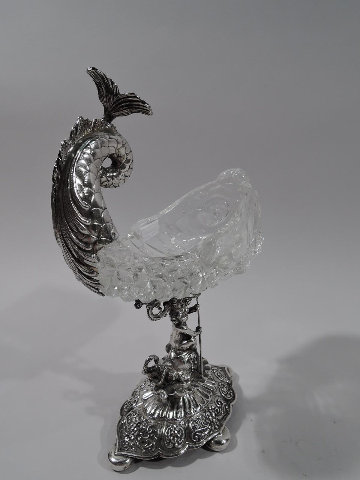 Turn-of-the-century German Renaissance 800 silver and cut-glass sweetmeat bowl. Cut-glass dolphin with up-turned silver-mounted scrolled tail. Support in form of trident-wielding cherub astride another dolphin. Raised and scalloped foot on 4