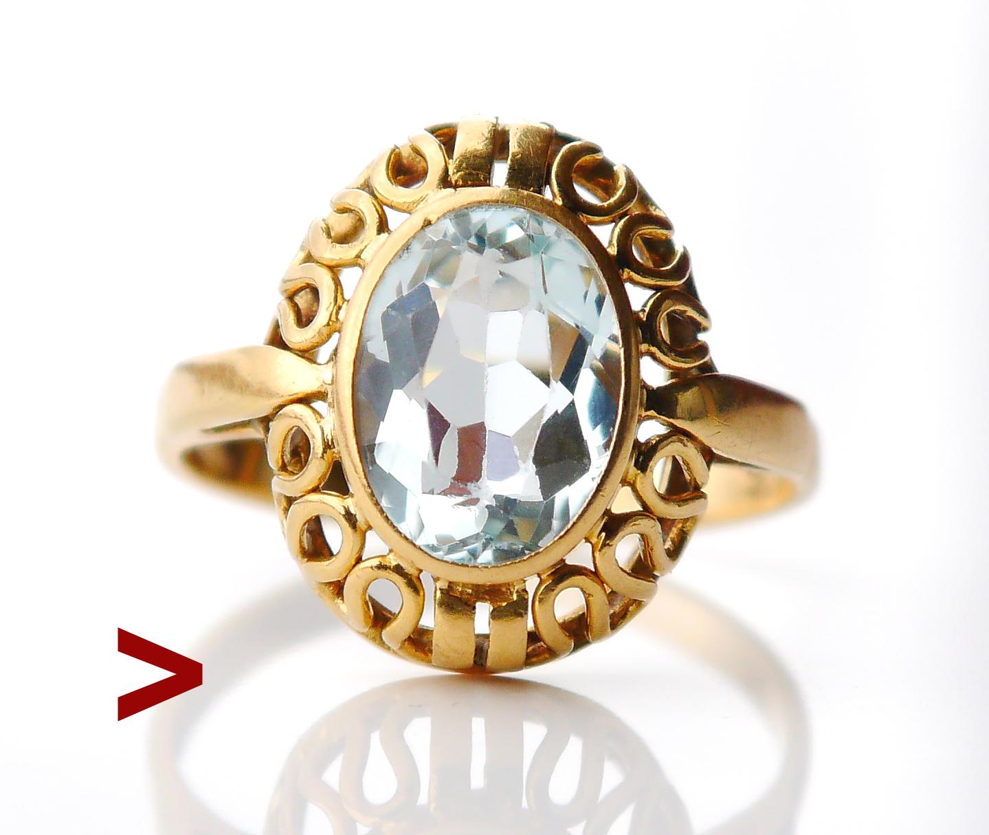 German ring with open-work crown and band in solid 18K Gold featuring natural transparent Aquamarine stone 10 mm x 8 mm x 4.6 mm / ca. 3 ct ct, color light Blue with tint of Green.

The Crown is 16 mm x 12 x 6 mm deep. Hallmarked 750 and logo of