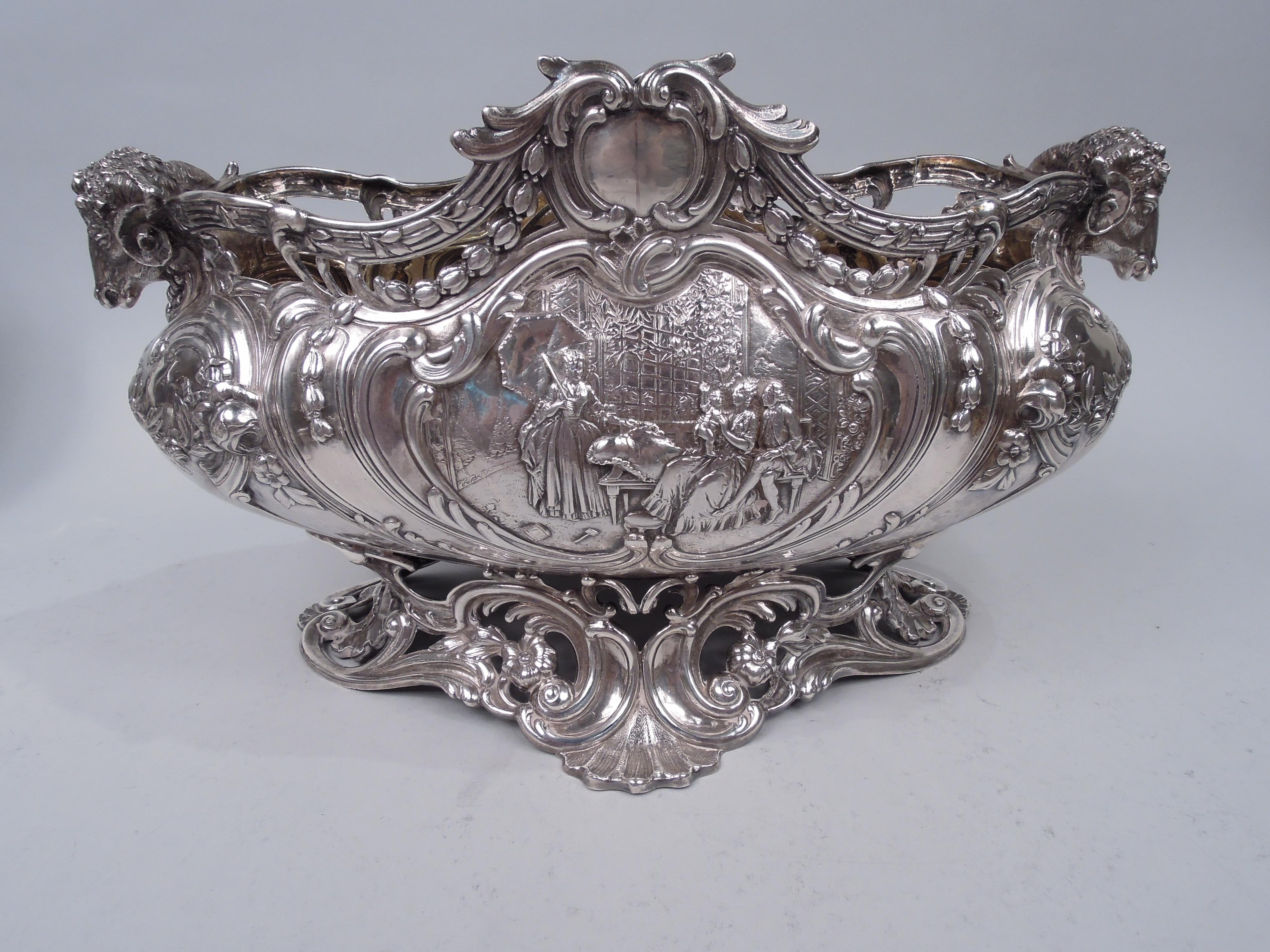 Rococo silver centerpiece bowl. Made by B. Neresheimer & Söhne in Hanau, Germany, and imported to England in 1905 by Berthold Muller in Chester. Bellied and ovoid with cast ram’s head end handles. Gilt-washed interior. Chased and engraved ornament.
