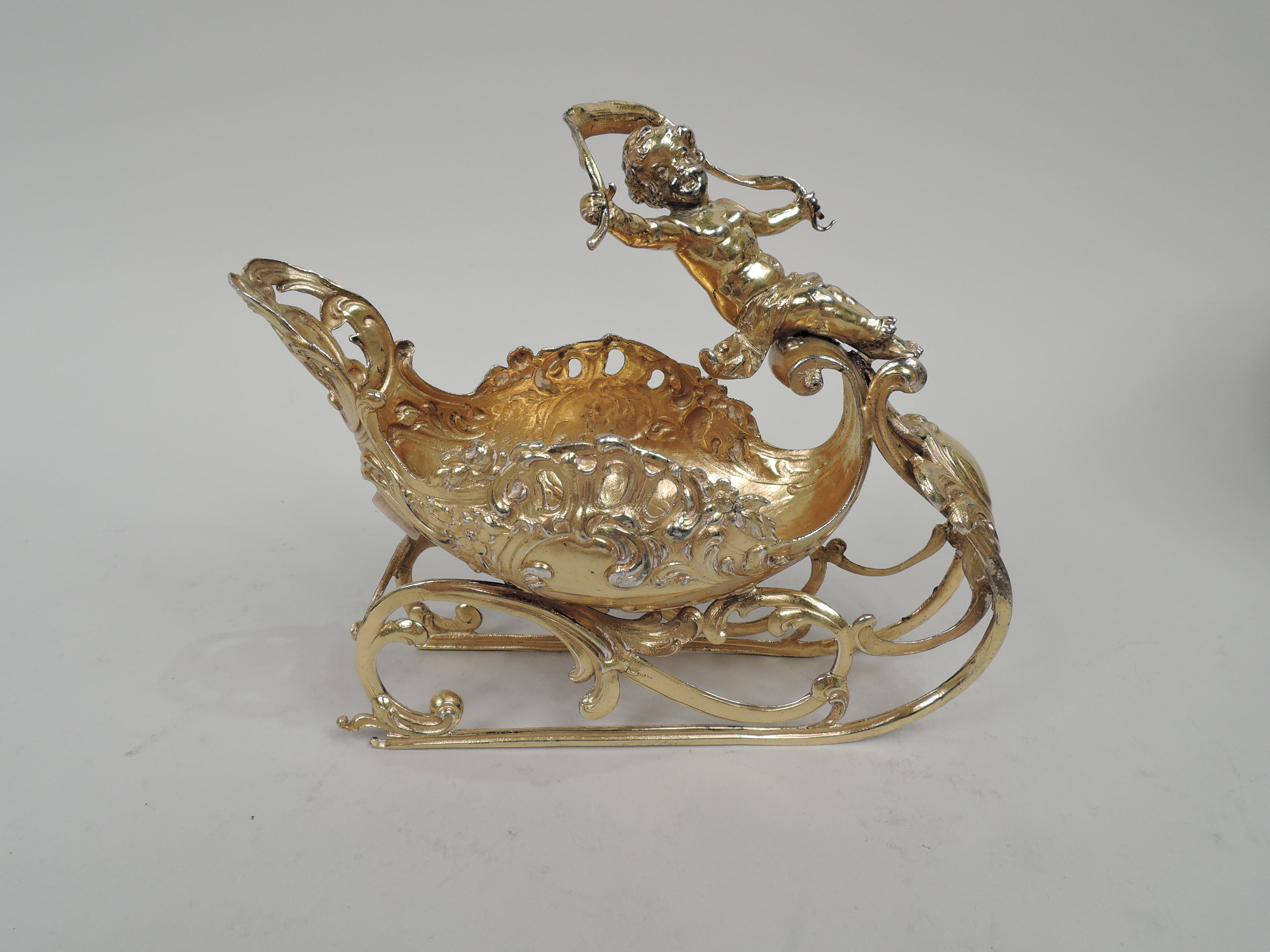 German Rococo silver gilt sleigh. Imported to England in 1899 by Berthold Muller. Ovoid bowl with chased and open scrolls and flowers on leafing-scroll stretchers. Mounted to front is scrolled cartouche (vacant) with irregular leaf surround. A