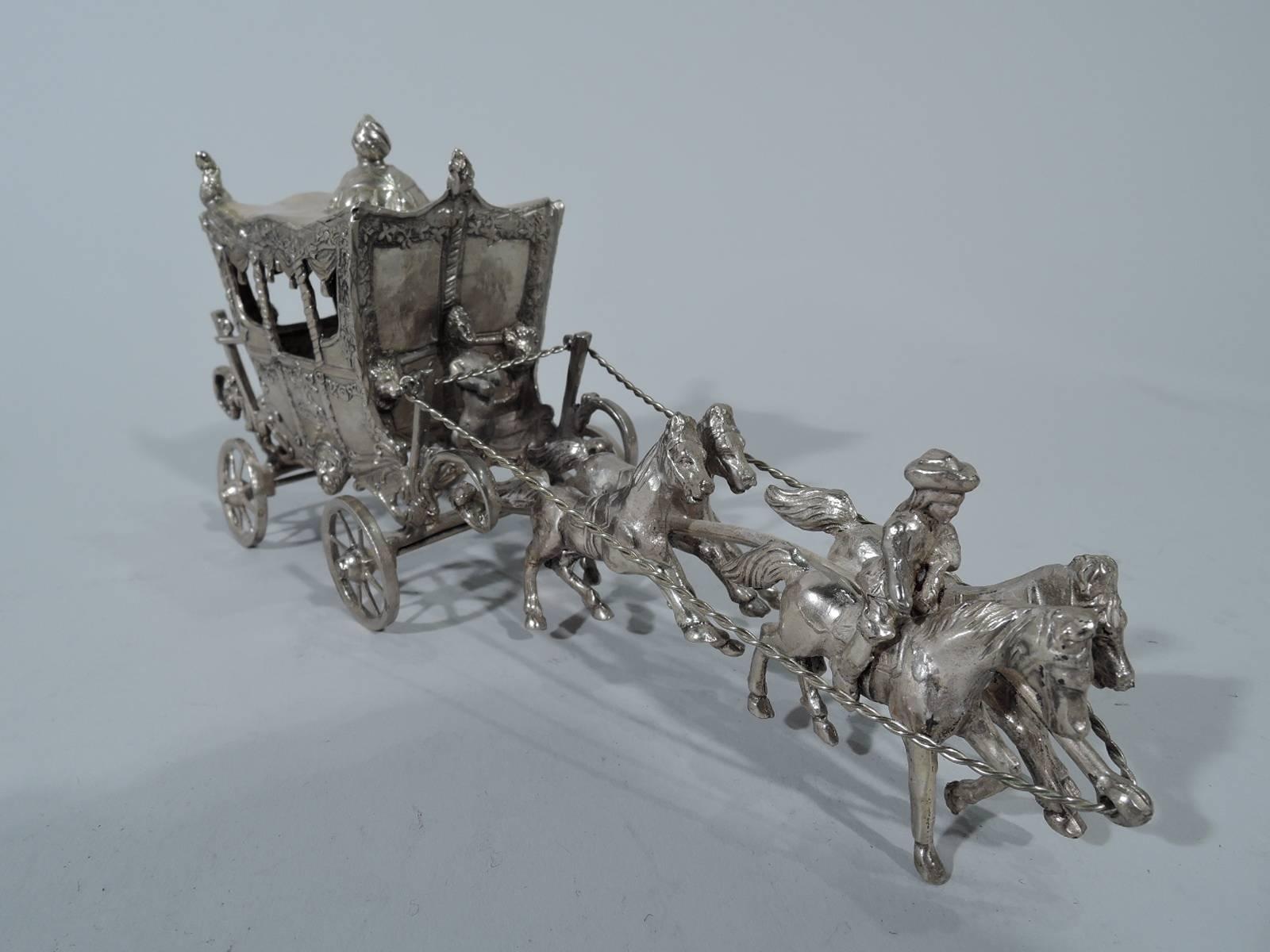 Antique German sterling silver coach-and-four. Exterior decorated with garlands and masks. Fancy swags hang inside windows. Caryatid coachman and postillions. Coach harnessed to four galloping horses (one mounted by man in tricorn hat). A sweet