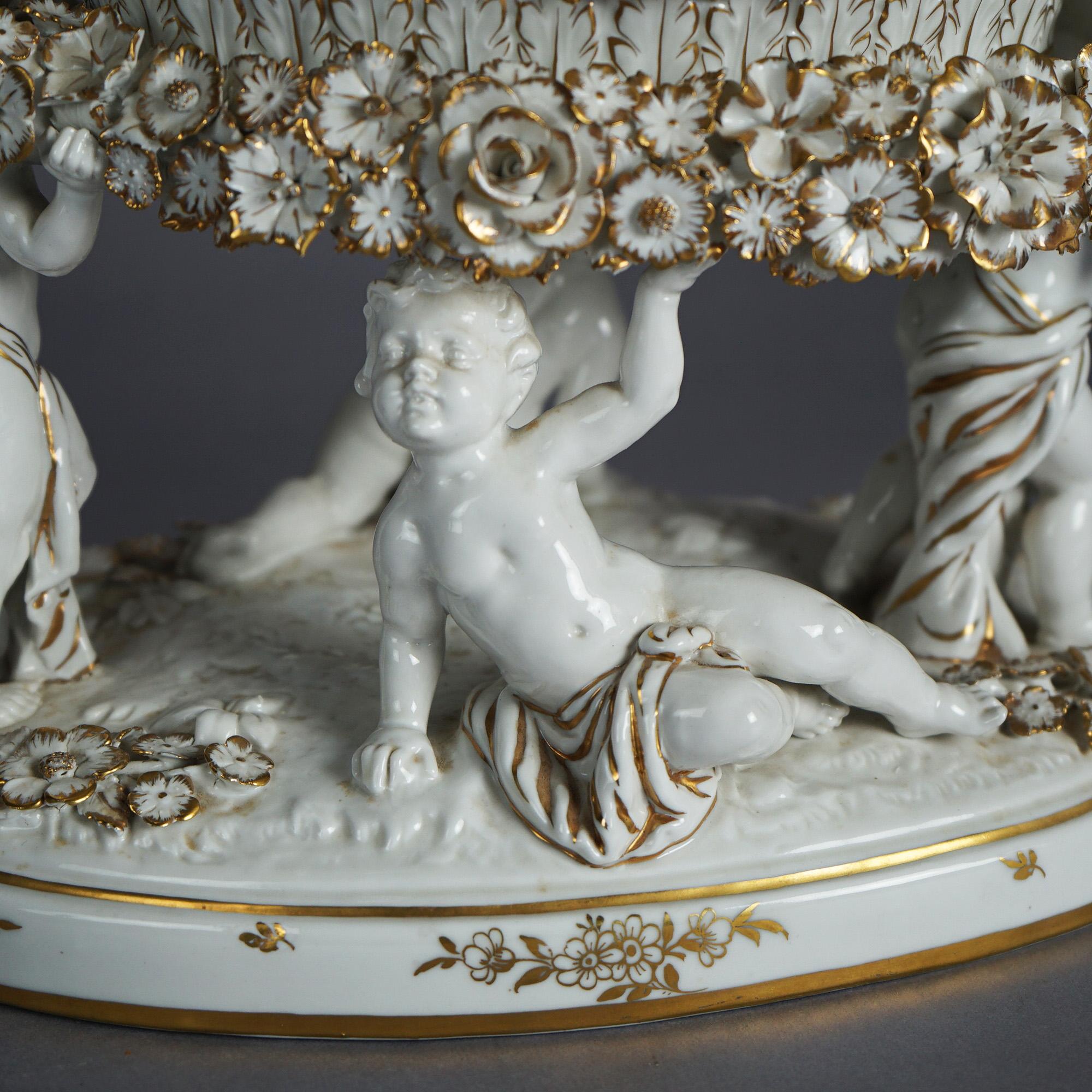 An antique German Schierholz center bowl offers porcelain construction with upper basket having reticulated rim over figural base with cherubs, gilt highlights throughout, c1920

Measures - 9.5