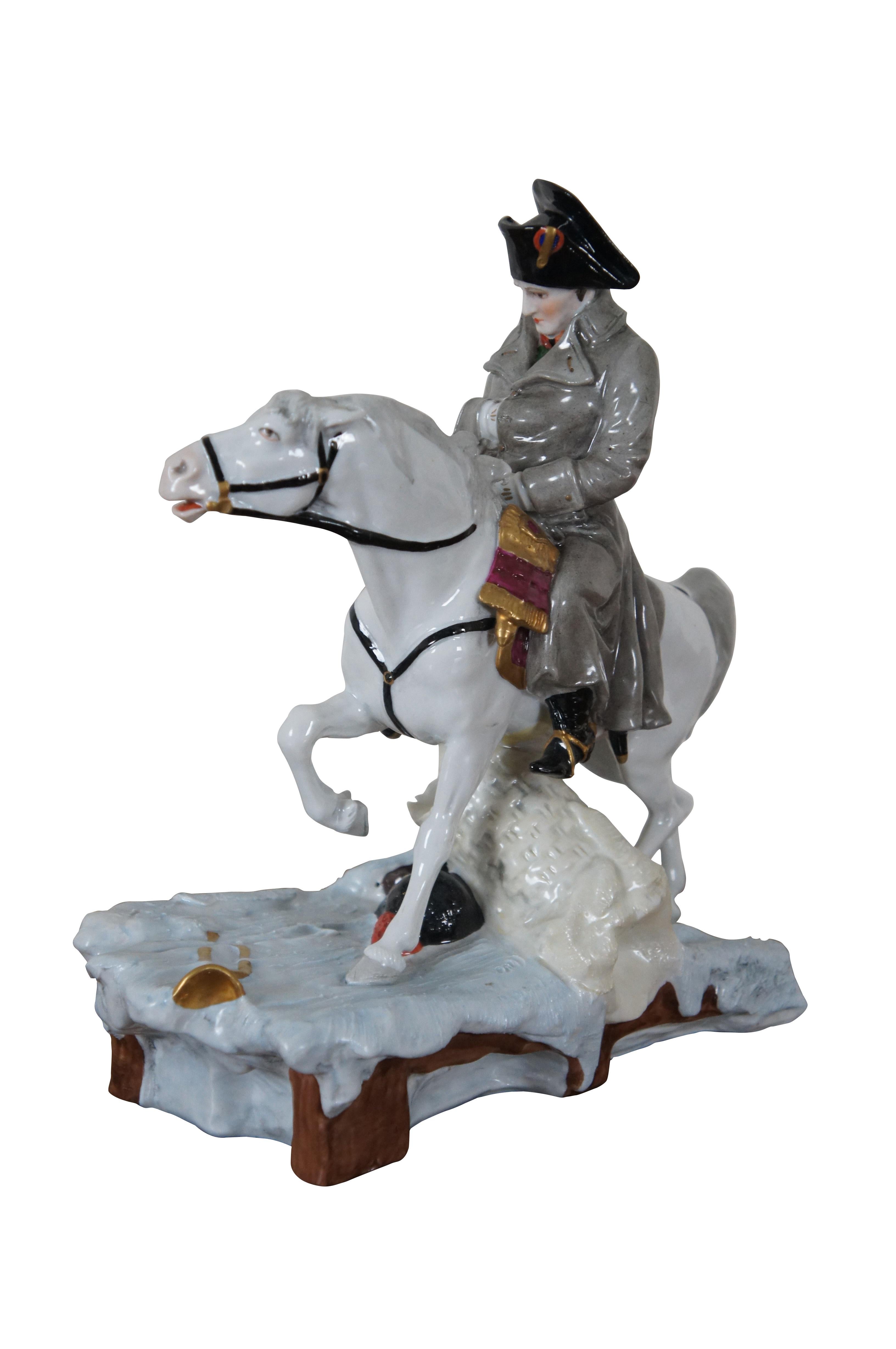 Antique German Scheibe-Alsbach / Sitzendorf / Kister porcelain figurine of General Napoleon Bonaparte wearing traditional attire with long overcoat, hand in pocket, riding a white stallion over the battlefield.

Dimensions:
9” x 4.5” x 10.25” (Width