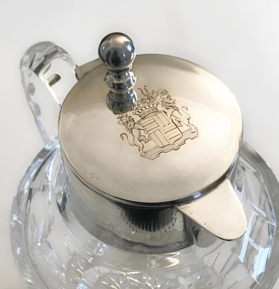 This stylish jug features a clear crystal body and a plain silver mount with a crest sign on top.
Marked 800 German silver trademark. 
Late 19th-early 20th century

Diameter at the top is 7 cm
Diameter at the bottom is 8 cm 
Circumference