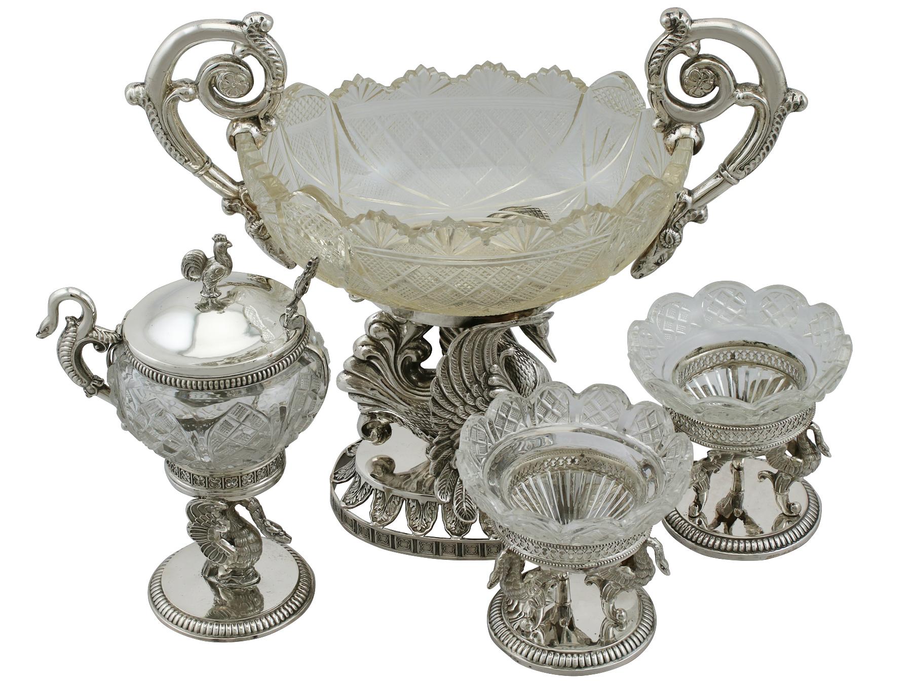 This exceptional antique German silver and glass table / cruet set consists of a bon bon dish, pair of salts and a mustard pot.

The impressive bon bon dish has an oval shaped form, incorporating the original cut glass vessel.

Either side of the