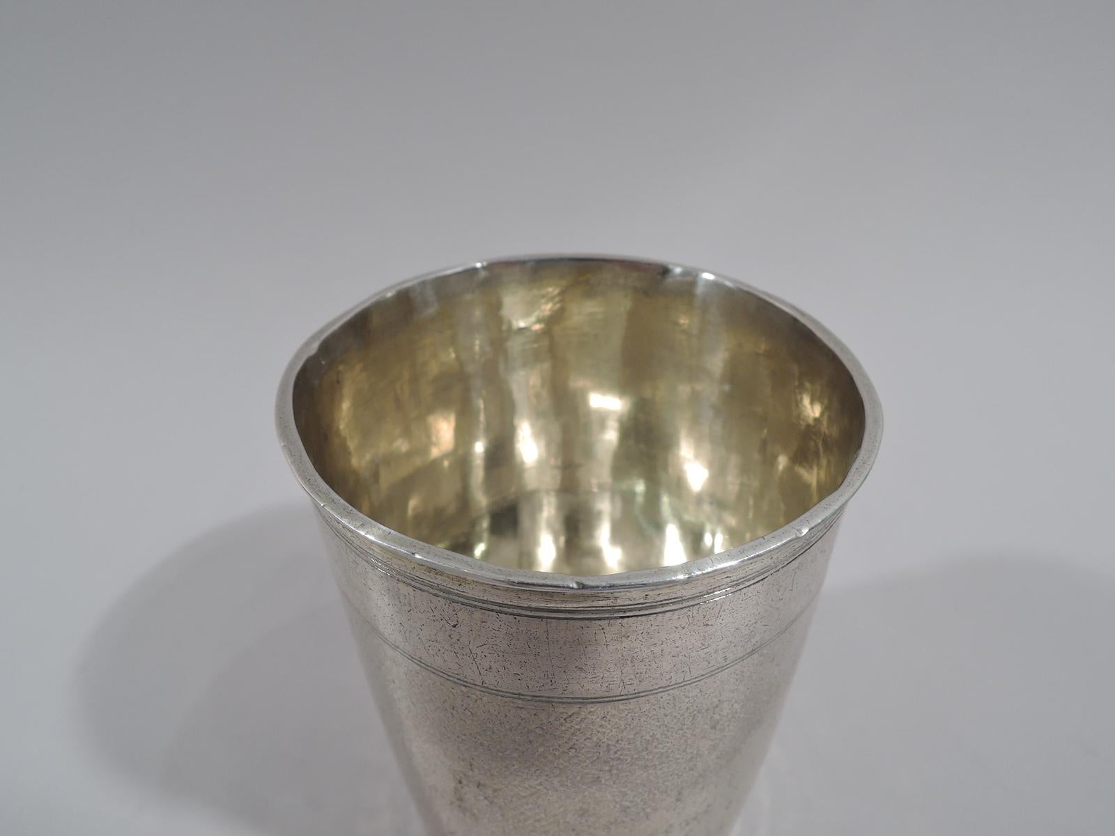 German silver beaker, 18th century. Gently tapering sides with all-over stippling. At top, plain band between engraved double lines. Nurnberg city mark and letters TR in circle. Weight: 4 troy ounces.