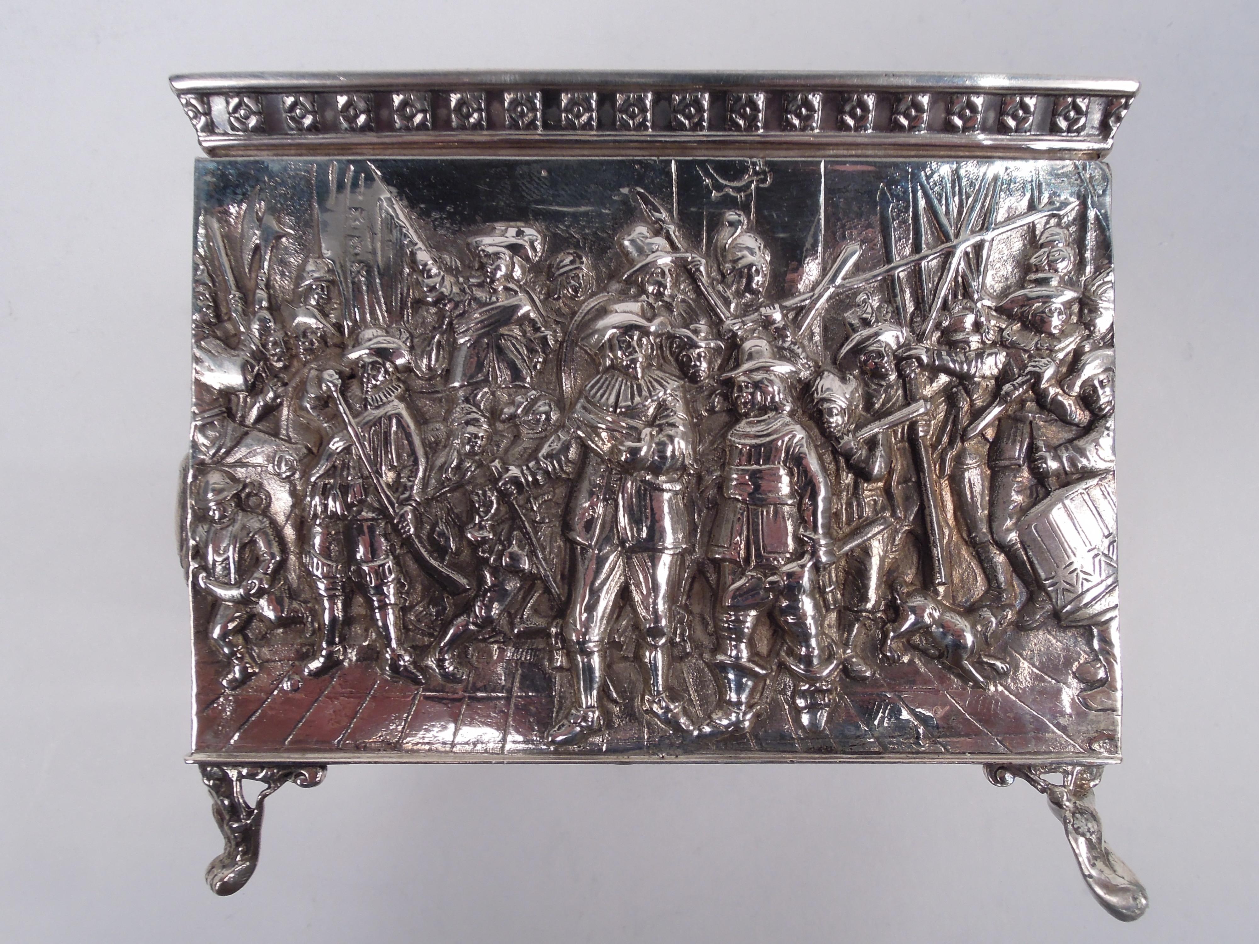 German 800 silver box, ca 1910. Rectangular with straight sides. Cover flat and hinged; tapering sides applied with flower head border. Embossed Olden Days scenes of merrymaking with dancing and flirting by men in neck ruffs and women in laced