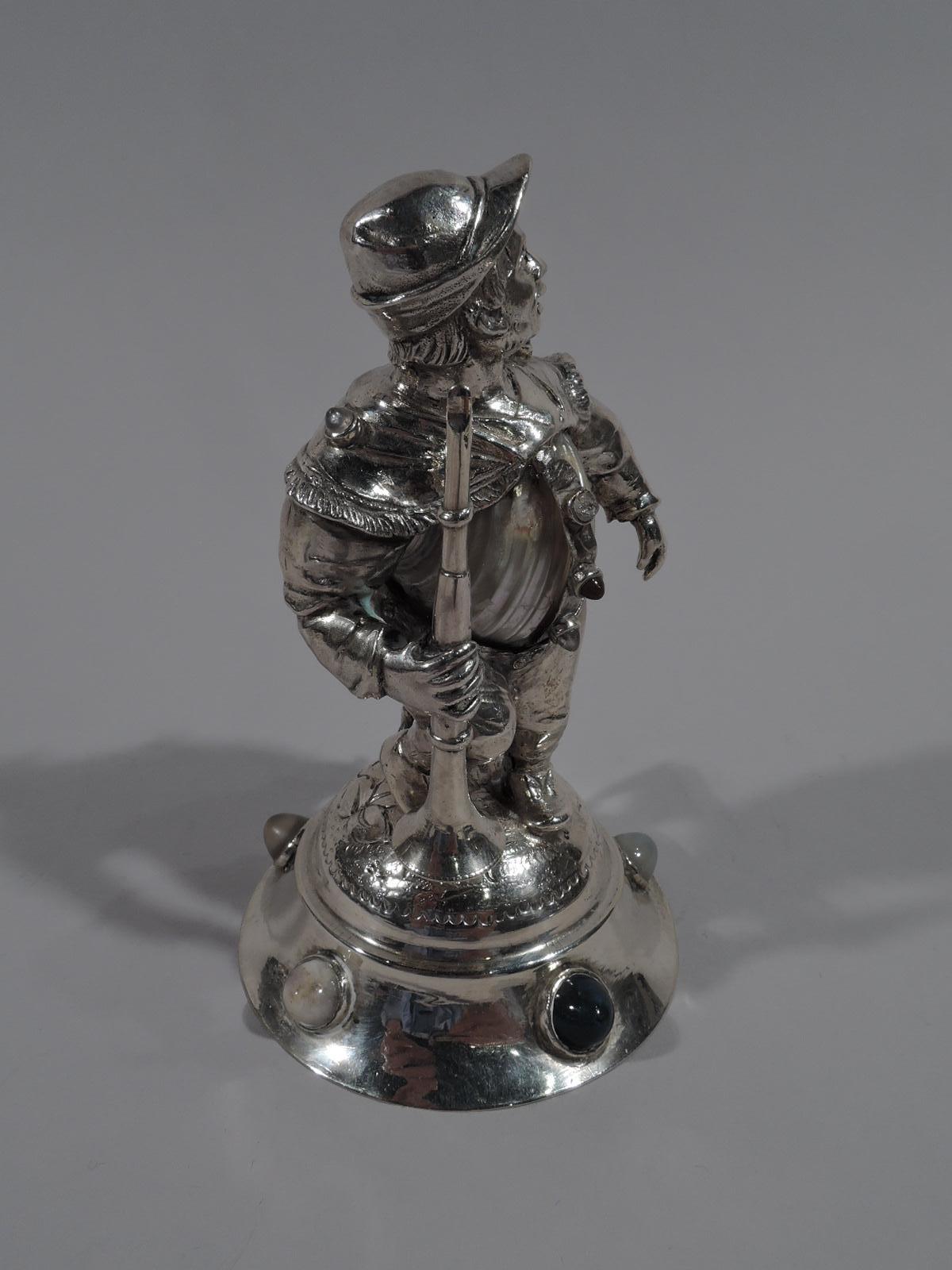 German 800 silver figurine, circa 1890. A shepherd boy holding a horn twists around in search of the stray lamb nuzzling his leg. Loose country garb reveals mother of pearl belly. Raised base inset with cabochon hardstones. Gentle humor with