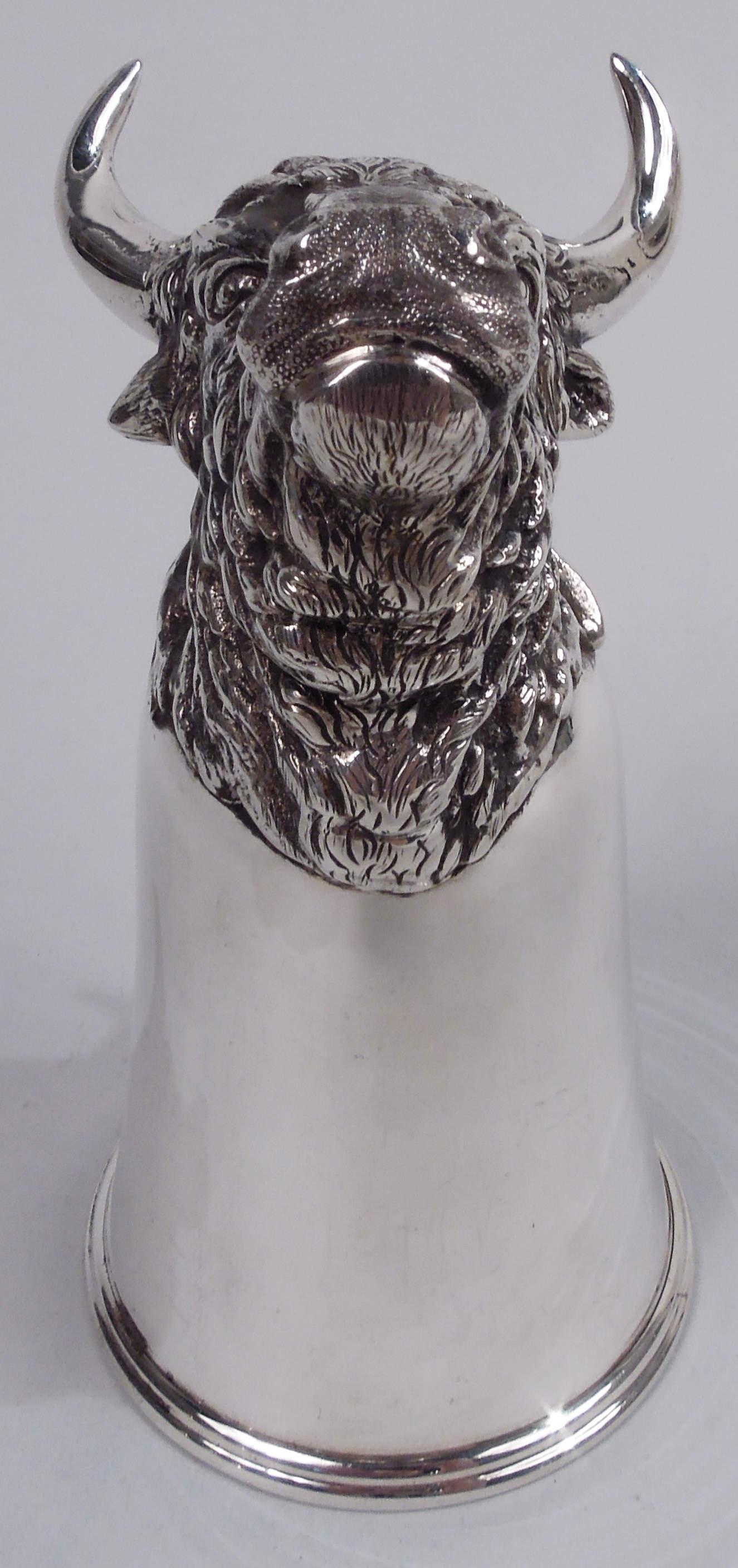 German 800 silver stirrup cup, ca 1910. Plain upward tapering bowl with molded rim; cast mount in form of bull head with thick, matted fur and pointy flexed ears under sharp, oversized alpha horns. Firmly closed mouth and direct stare suggest a