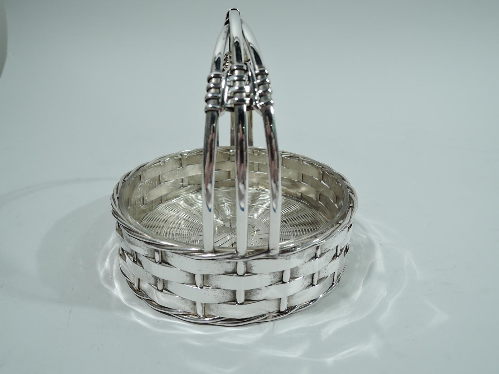 German 800 silver basket. Made by Friedrich Wilhelm Quist in Esslingen, ca 1910. Round with straight and woven sides, and twisted rim and base. C-scroll stationary handle comprising 3 wire-wrapped strands. Detachable clear glass liner. Marks include
