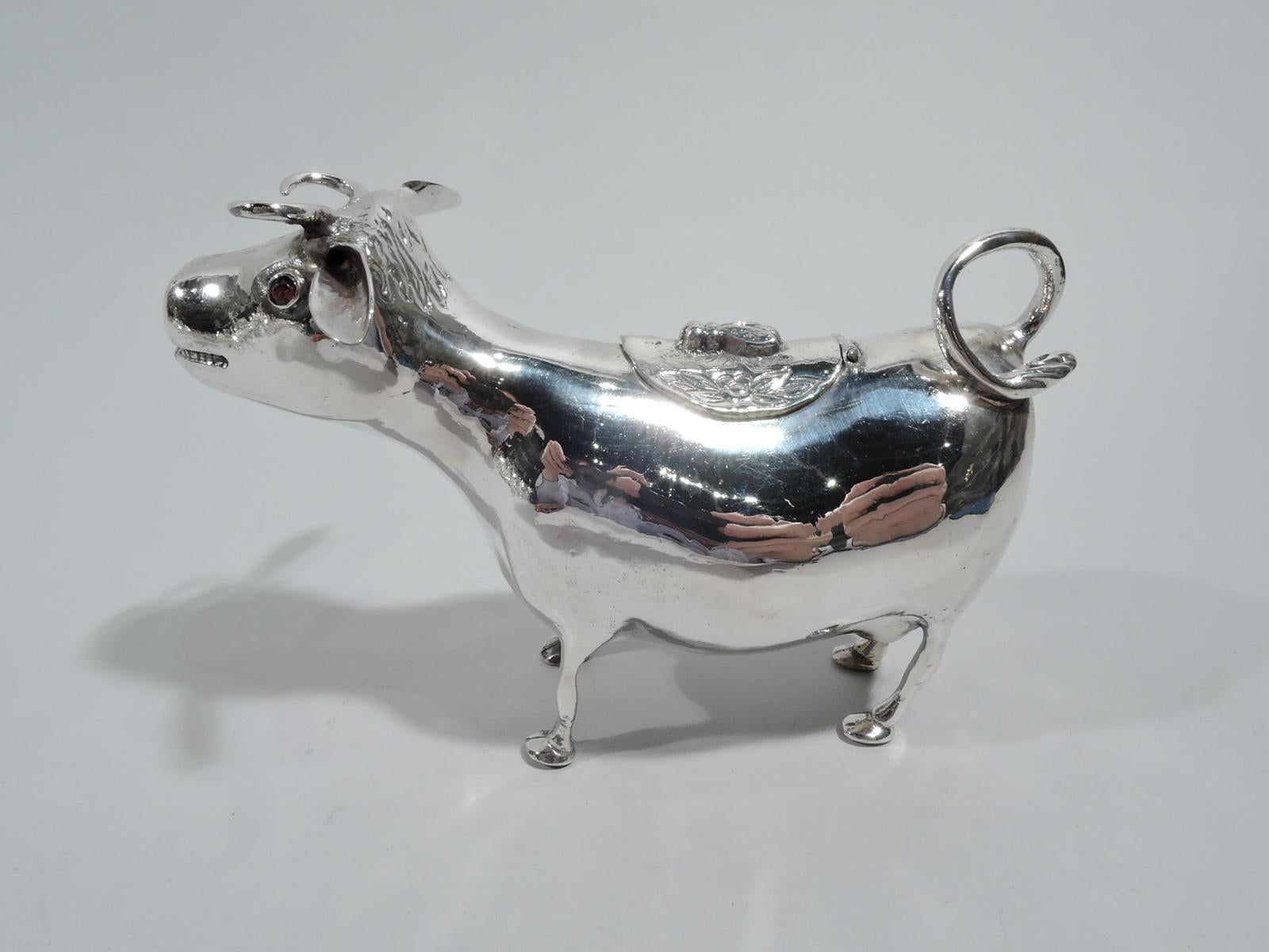 Turn-of-the-century German 800 silver cow creamer. Heavy-set body on skinny legs and firmly planted hoofs. Flicked-back tail handle and hinged back cover with fly finial. A sweet and simple beast with smiley mouth spout and funny flexed ears.