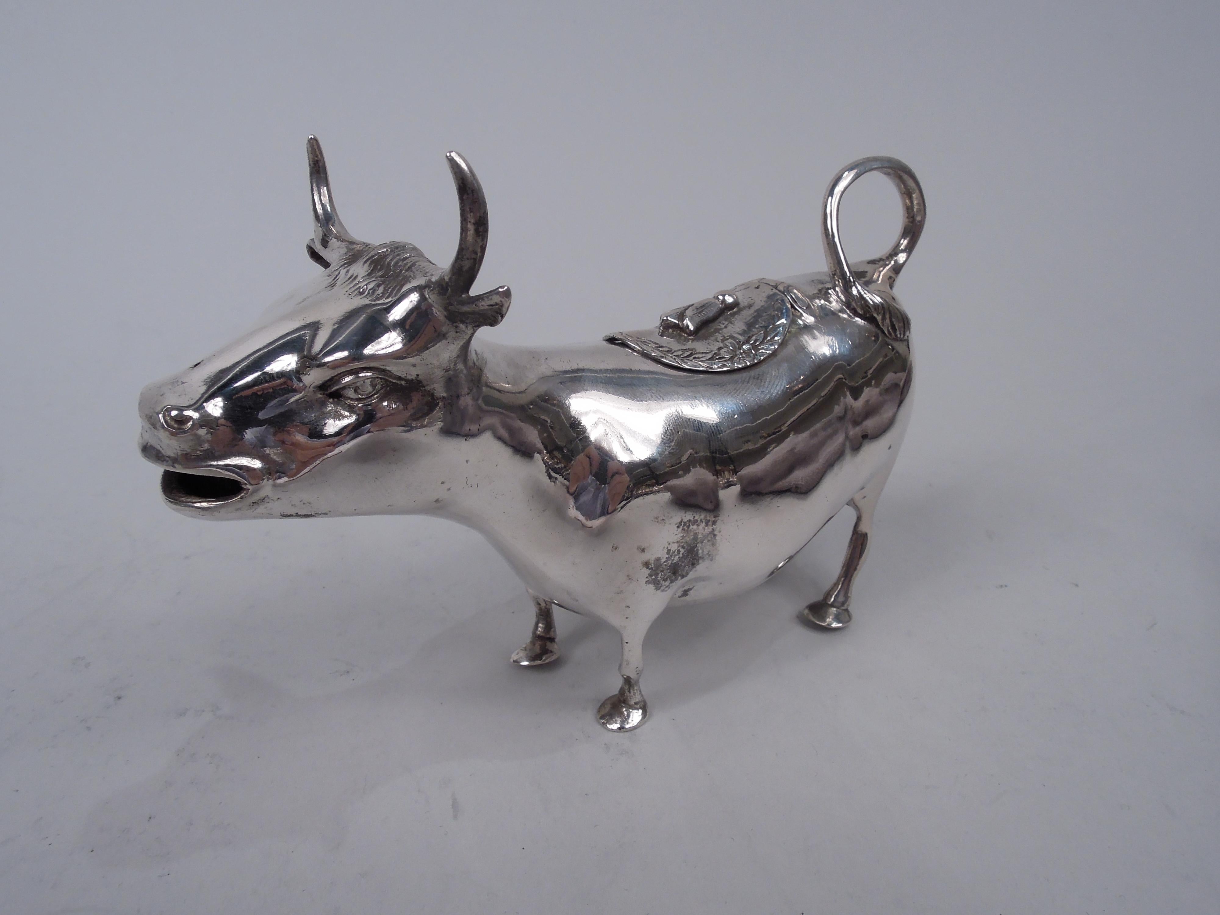 German 800 silver cow creamer, ca 1910. A sweet bovine with upturned horns, flexed ears, and smiley mouth spout. Sturdy sagging body with ring-handle tail and hinged back cover with fly finial. Stands on firmly planted hooves. Unidentified Hanau
