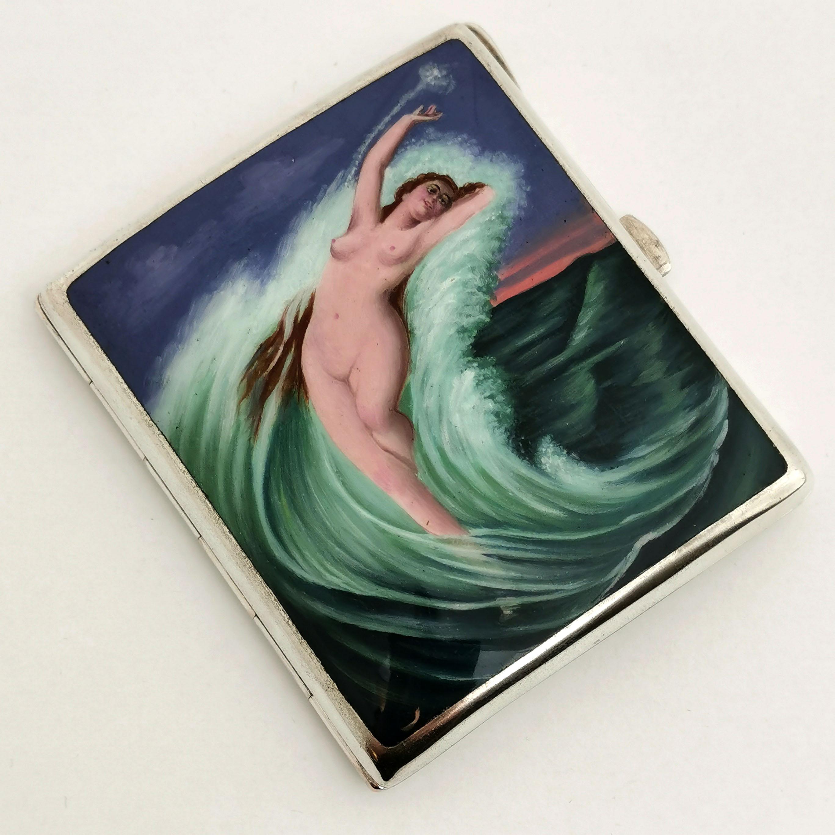 A gorgeous Antique solid Silver Cigarette Case with an Enamel Image on the front cover. This Image shows a nude woman with long brown hair surrounded by a cresting wave in the ocean. The Enamel Image is created in rich jewel tones and with a lovely