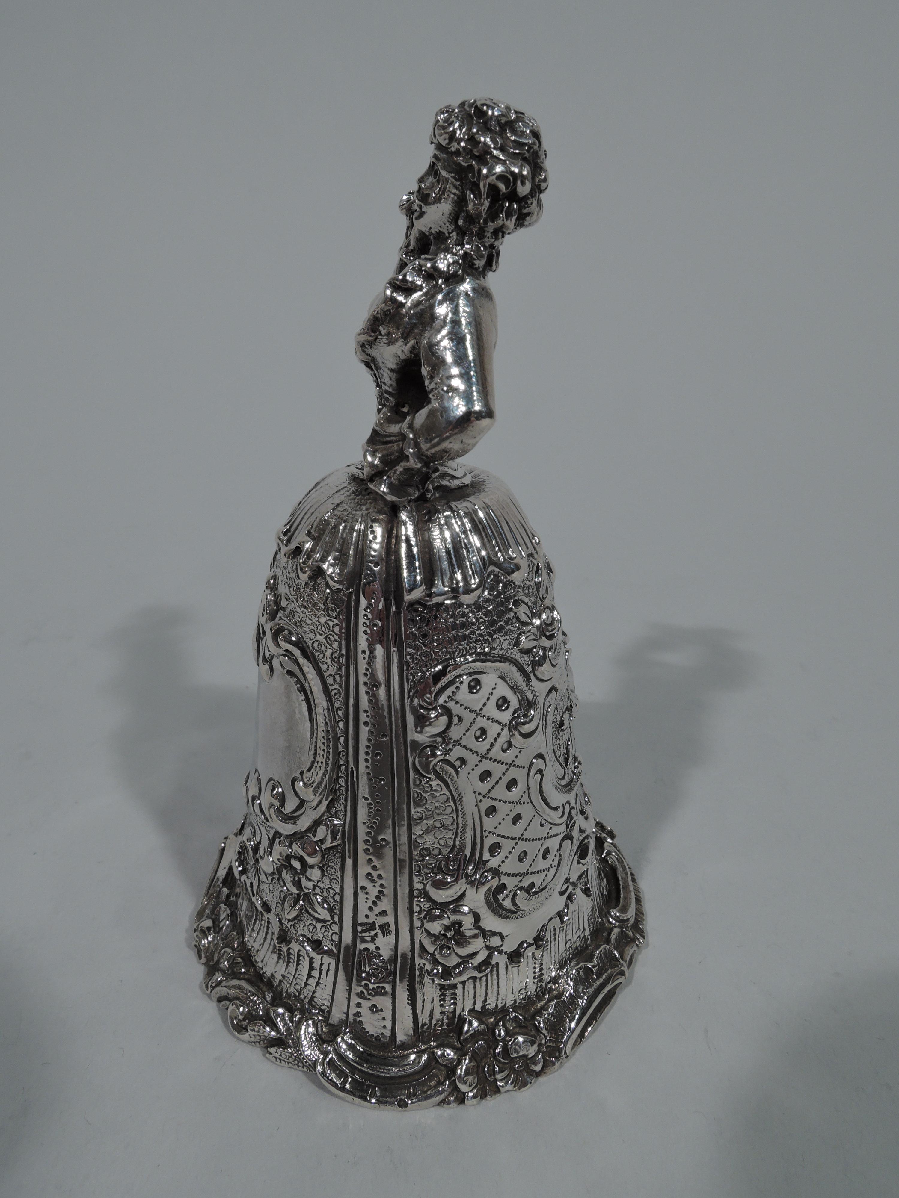 German 800 silver figural bell, circa 1900. A bosomy, tightly corseted lady holds a fan with hand on hip and a bouquet in raised other. Voluminous skirt with applied scrolled rim and scrolled cartouche (vacant). Hallmarked. Weight: 3.5 troy ounces.
