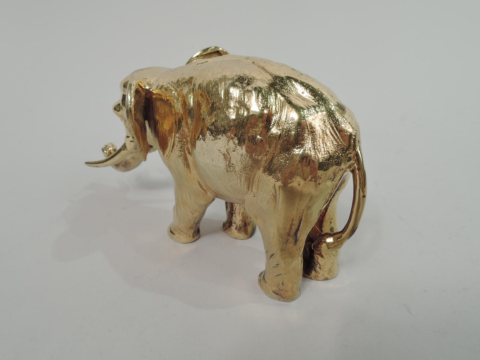 Turn-of-the-century German gilt 800 silver elephant figure. A majestic beast with big funny ears, upturned trunk, and long sharp tusks rumbling along on massive legs. Nuanced depiction of wrinkles and sags. Marked. Weight: 7.5 troy ounces.