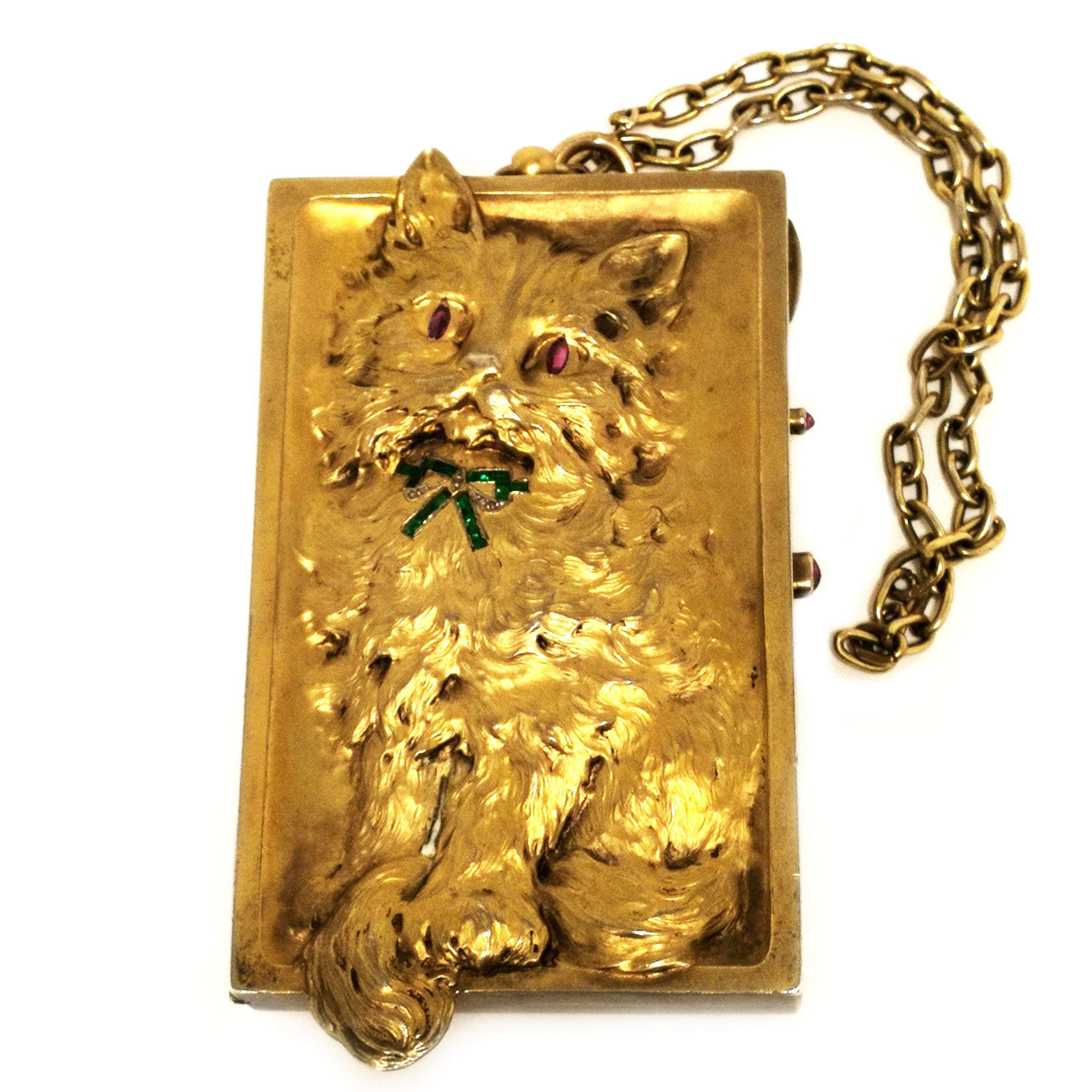 A magnificent antique German solid silver gilt Minaudière embellished with a chased silver cat in deep relief on the front of the case, with the back of the cat on the back cover. The cat is inset with precious jewels with ruby eyes and an emerald