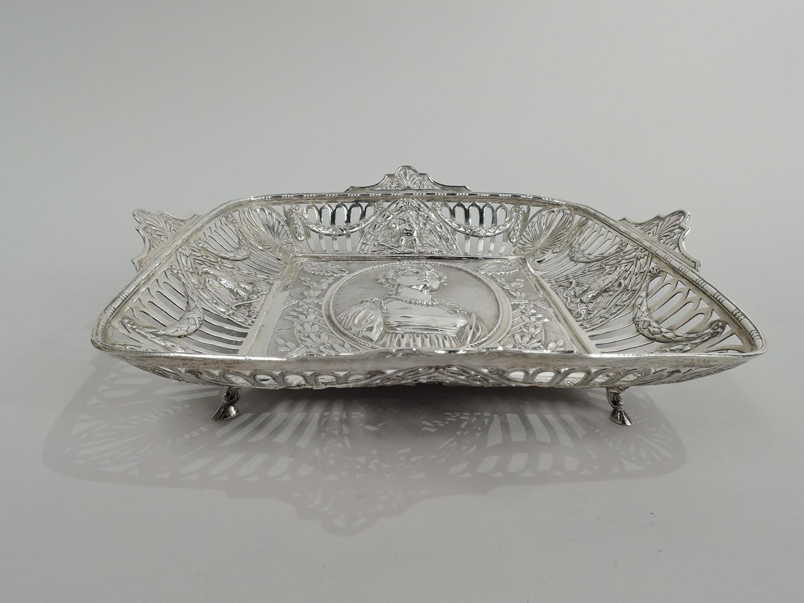 German 800 silver bowl with Napoleonic theme, ca 1910. Square. Sides tapering with open arcade interspersed with imperial eagles and corner palmettes and overlaid with swags. Bead-and-reel rim has curvilinear mounts inset with palmette. Well has