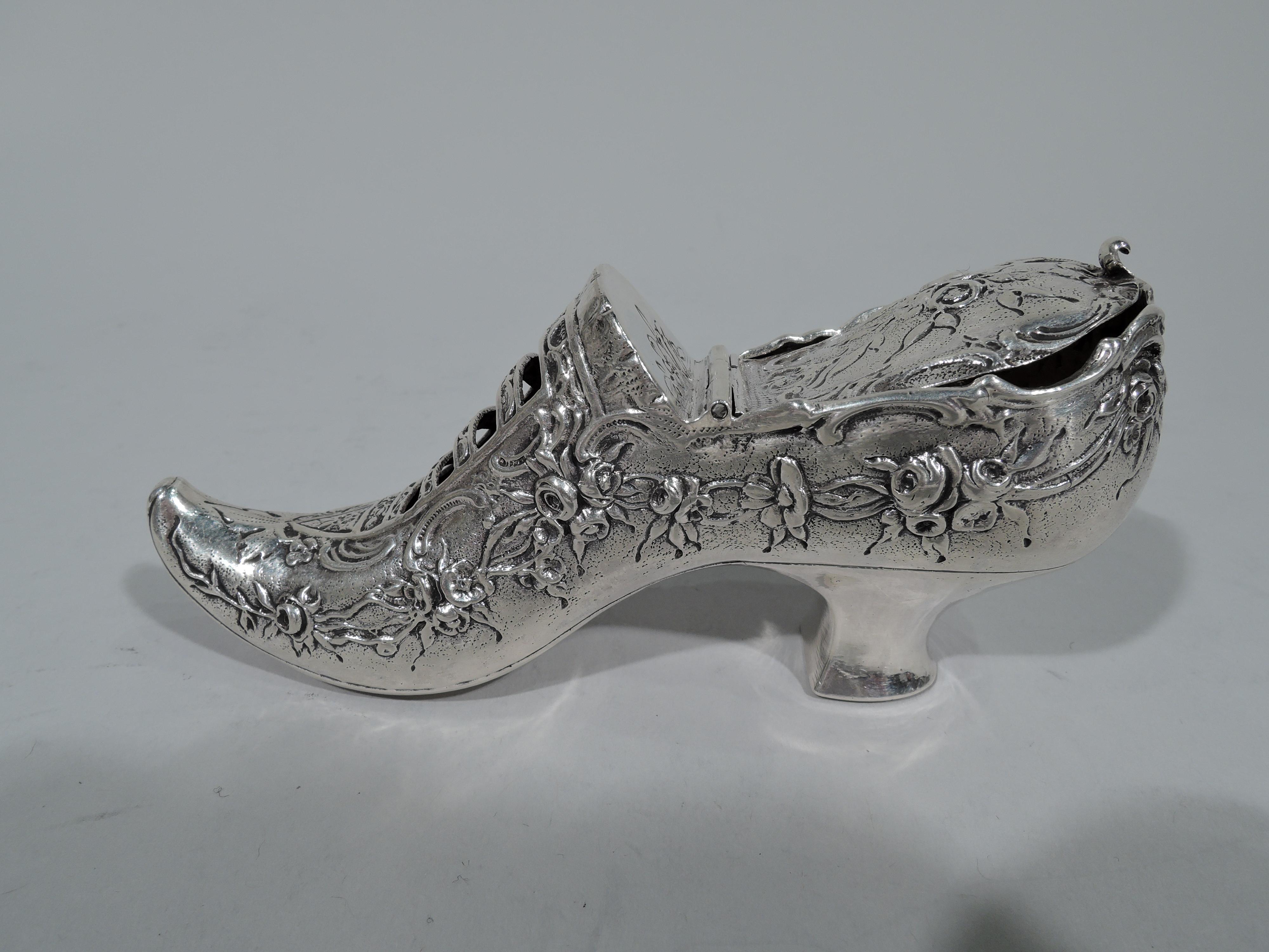 German 930 silver novelty trinket box. Imported to England in 1900 by Elly Isaac Miller in London. Rococo shoe with chased floral garlands and open bands. Insole has hinged cover. Raised elf toe and plain heel. German maker’s and English importer's