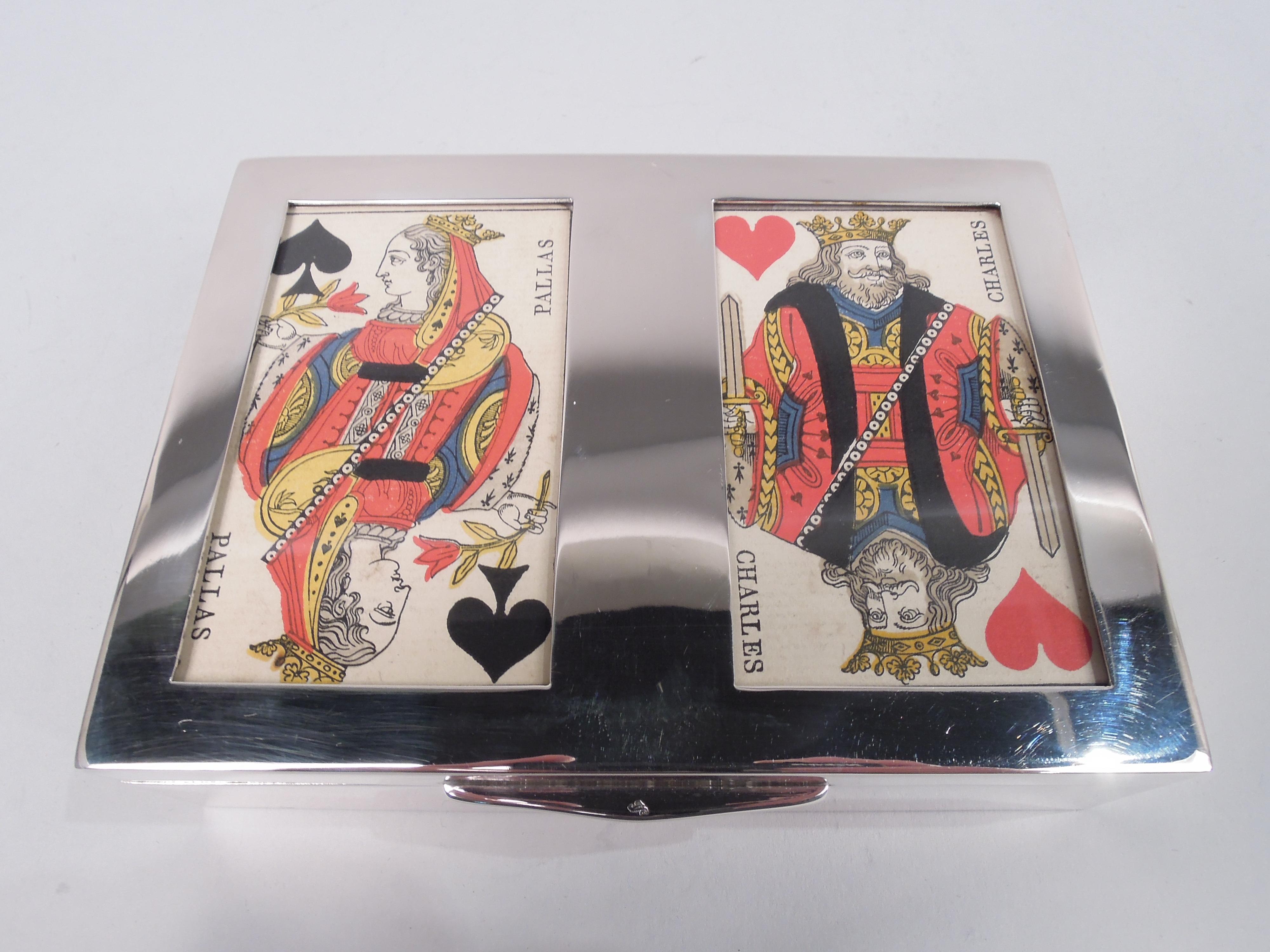 German 800 silver playing card box, ca 1920. Rectangular with straight sides. Cover hinged with chamfered tab; top flat with two glazed windows faced with a King of Hearts and Queen of Spades. Interior wood-lined and partitioned with ribbon tabs.