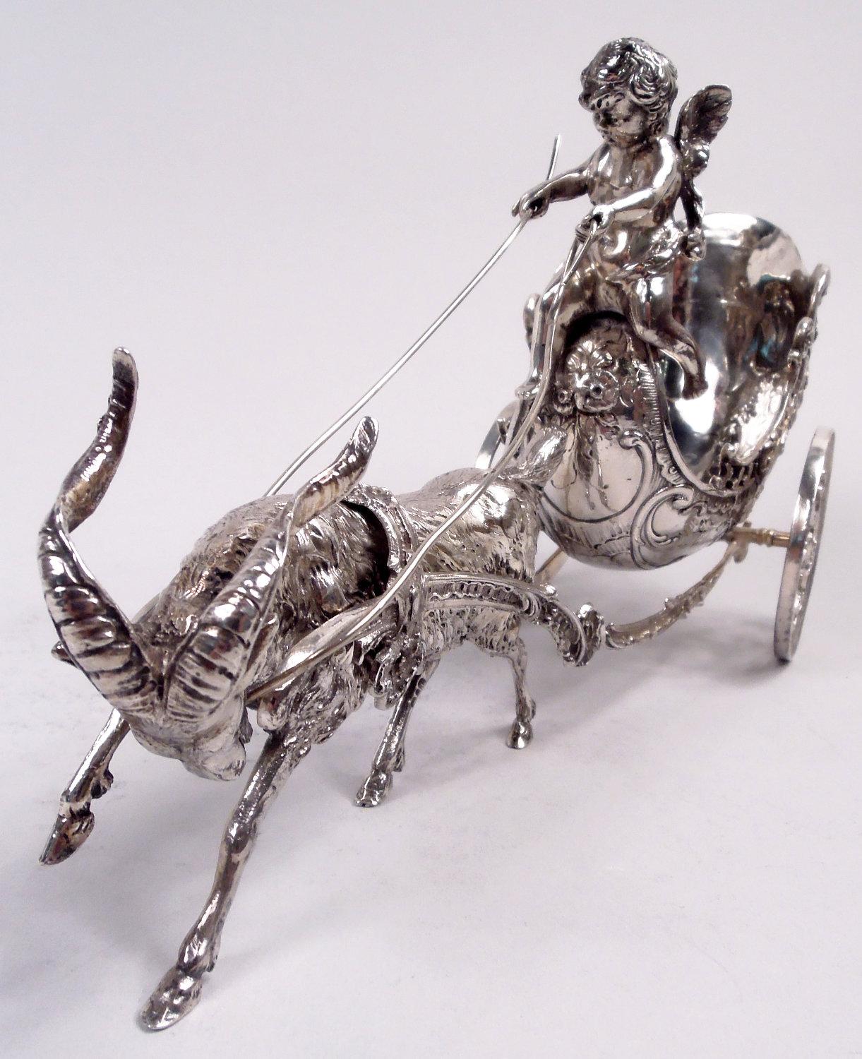 German Rococo silver coach. Imported to England by Berthold Muller in 1903. Cupid (Love) is in the driver’s seat but struggles to control the reins of a harnessed goat. A frisky metaphor expertly detailed in the goat’s bowed head and twisting horns,