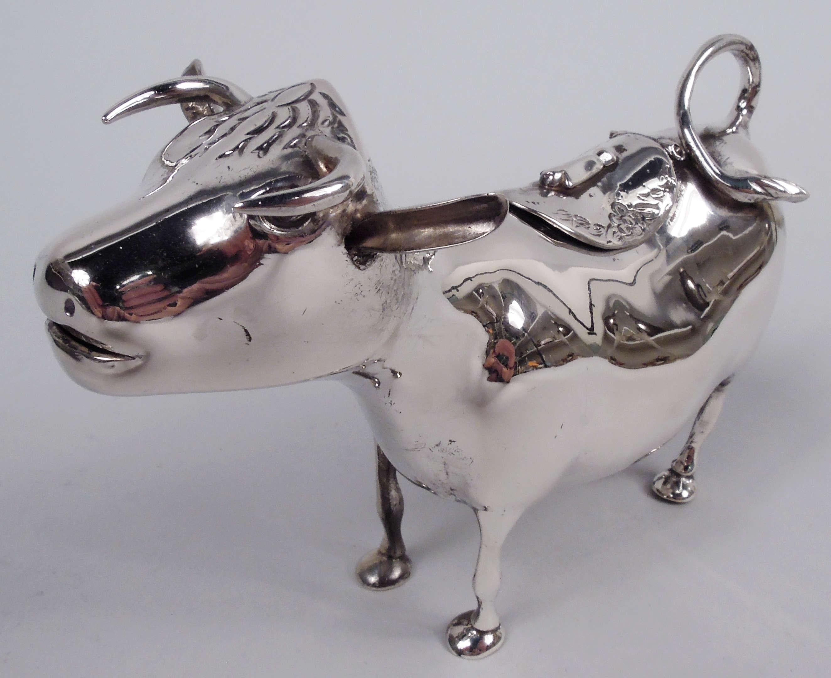 German 800 silver cow creamer, ca 1910. A sweet beast with flexed ears, stubby horns, and slightly agape mouth spout. A stocky body with spindly legs and firmly planted hooves; flicked-back tail handle and hinged flap for refills. Marked. Weight: