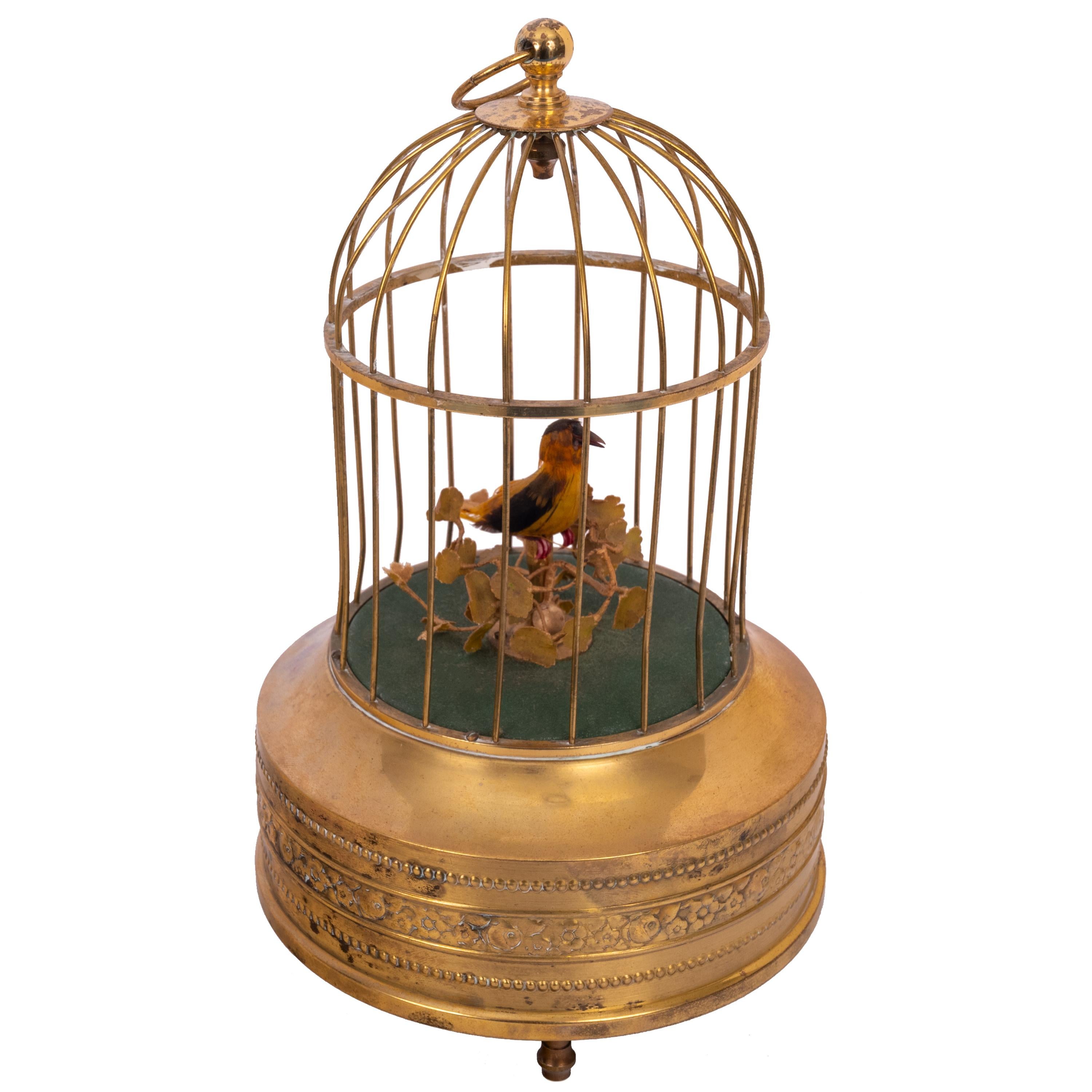 A good antique singing bird in a cage automoton, Karl Griesbaum, circa 1930
A feathered single bird sings its various bird song calls while moving its tail and beak and swiveling its head inside a brass cage. Dating from around 1930, the base is