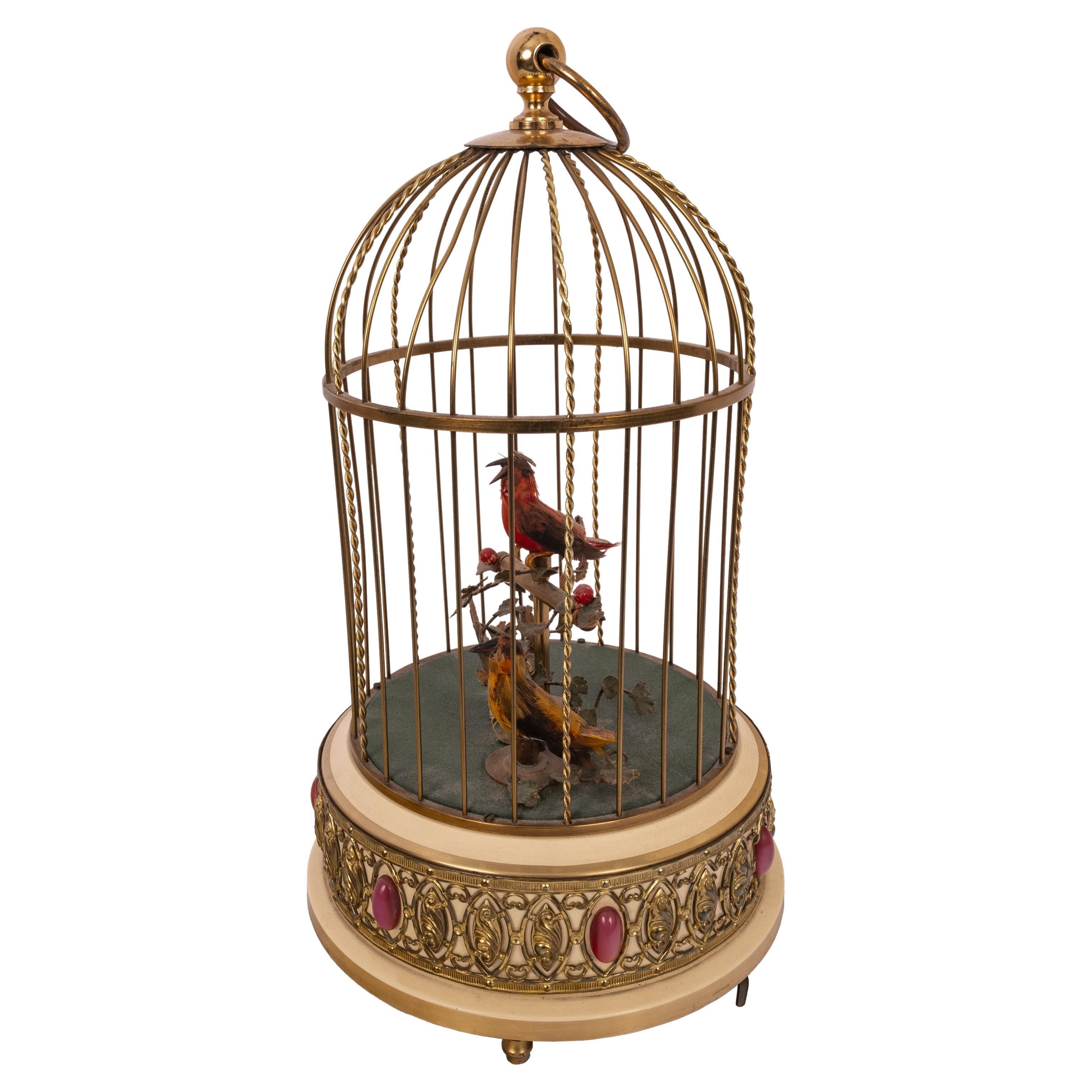A good antique twin singing birds in a cage automoton, Karl Griesbaum, circa 1950
A pair of feathered birds sing various bird song calls while moving their tails and beaks and bodies and swiveling their heads inside a brass cage. Dating from around