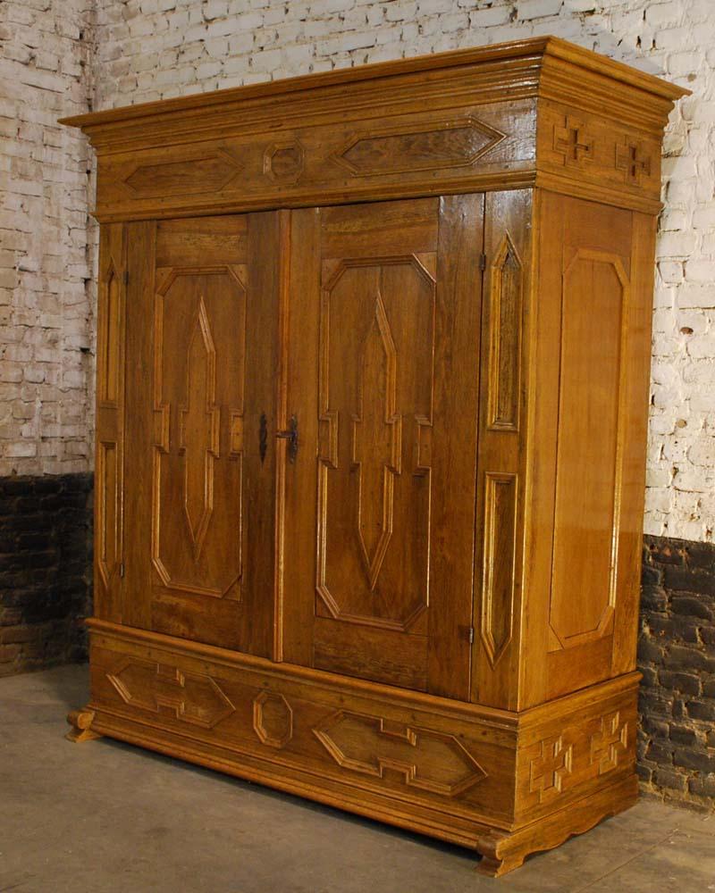 A beautiful light honey colored solid oak wardrobe with intricate molding throughout the whole cabinet. 
Its appearance and build quality make it a rich wardrobe cabinet from Germany that dates approximately 1760. 
It originates in the region