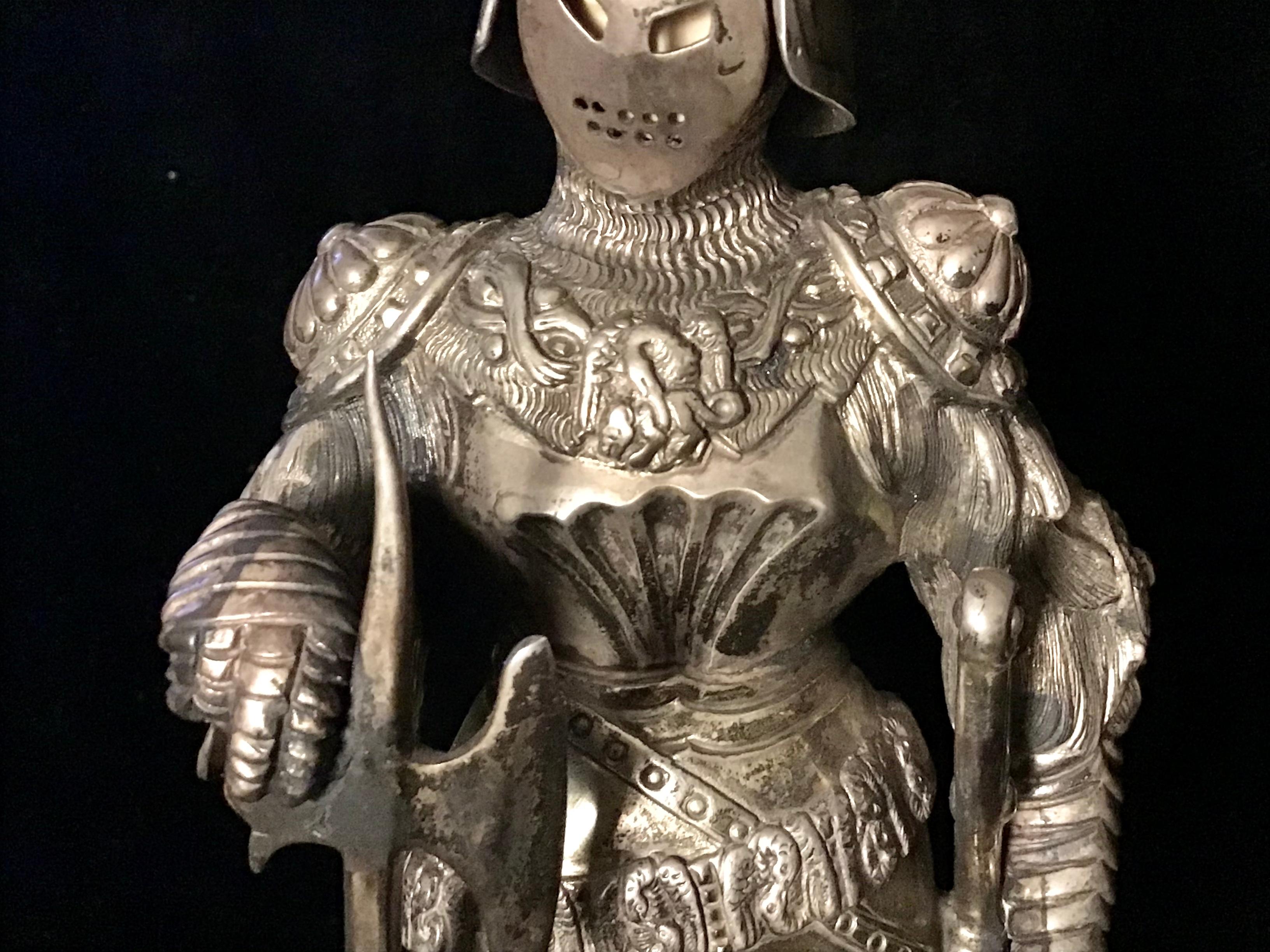 Antique early-20th century large and fine German solid silver figure, modelled as a knight in full suit of armour, carved face beneath a hinged visor, one sporting a axe and the other a shield, chased with armorials. Standing on a large, embellished