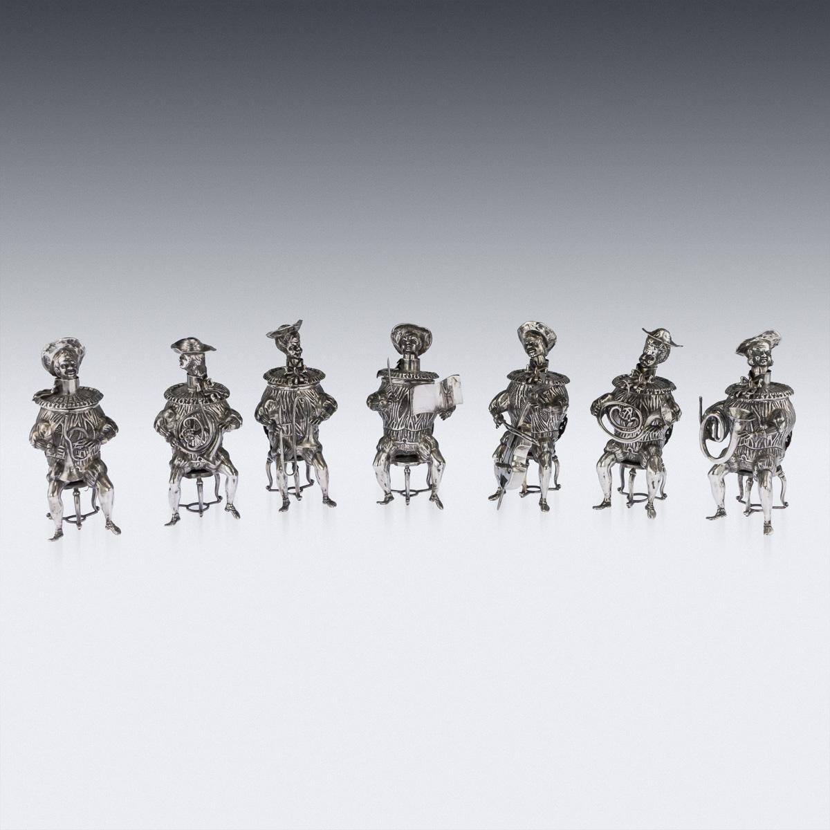 Antique early-20th century German exceptionally rare set of seven solid silver novelty cups modelled as a band of musicians seated on chairs, each with a cast round body and sprung head, plumed hat and ruffled collar, removable tops.

Hallmarked