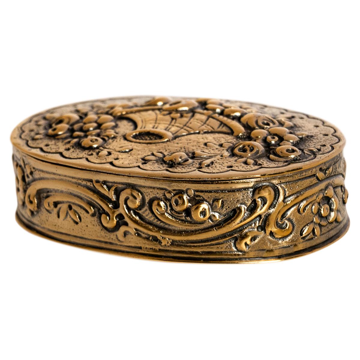 Elegante caja de rapé o pastillero alemana de plata de ley dorada y decorada con repujado, hacia 1880.
La tapa abisagrada está decorada con un diseño de cesta floral repujado, y el lateral de la caja tiene el correspondiente diseño floral y de