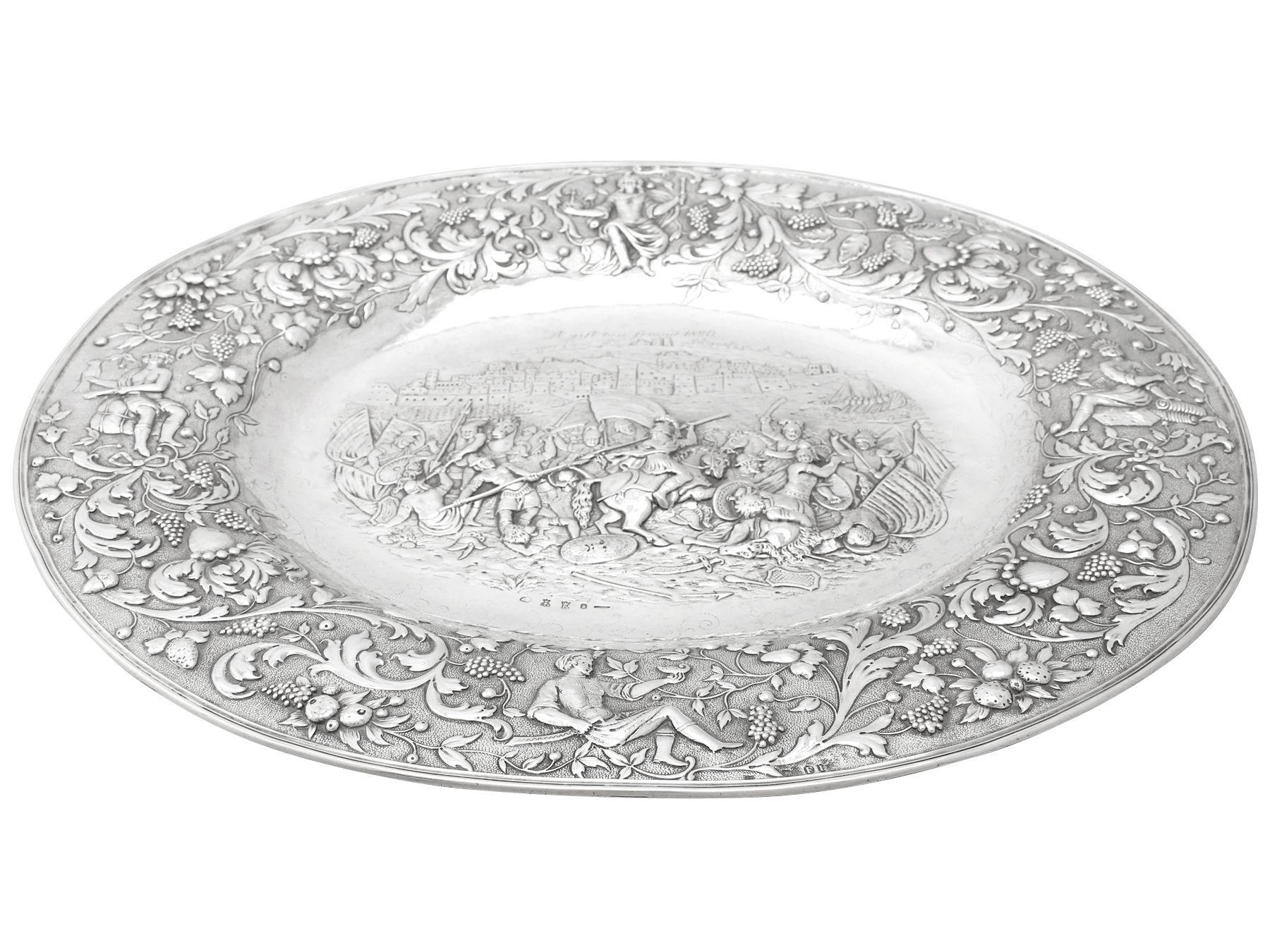 A magnificent, fine and impressive, large antique German sterling silver charger plate.

This magnificent antique German sterling silver charger plate has an oval form.

The surface of the charger plate is embellished with an exceptional