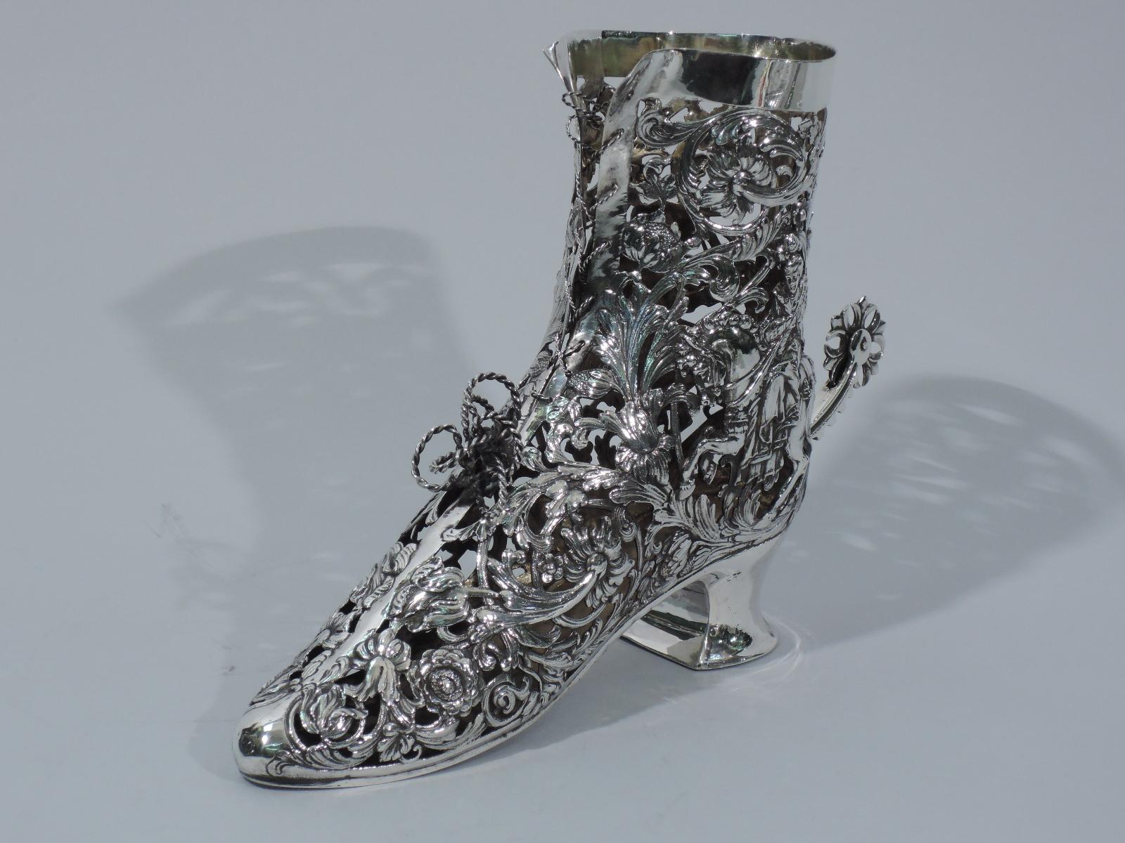 German sterling silver lady’s riding boot. Imported to England by Berthold Muller in 1906. Plain and solid sole, heel, and topline. Pierced body comprising leafy-scrolls and flowers with Renaissance lady riding sidesaddle and huntsman with falcon