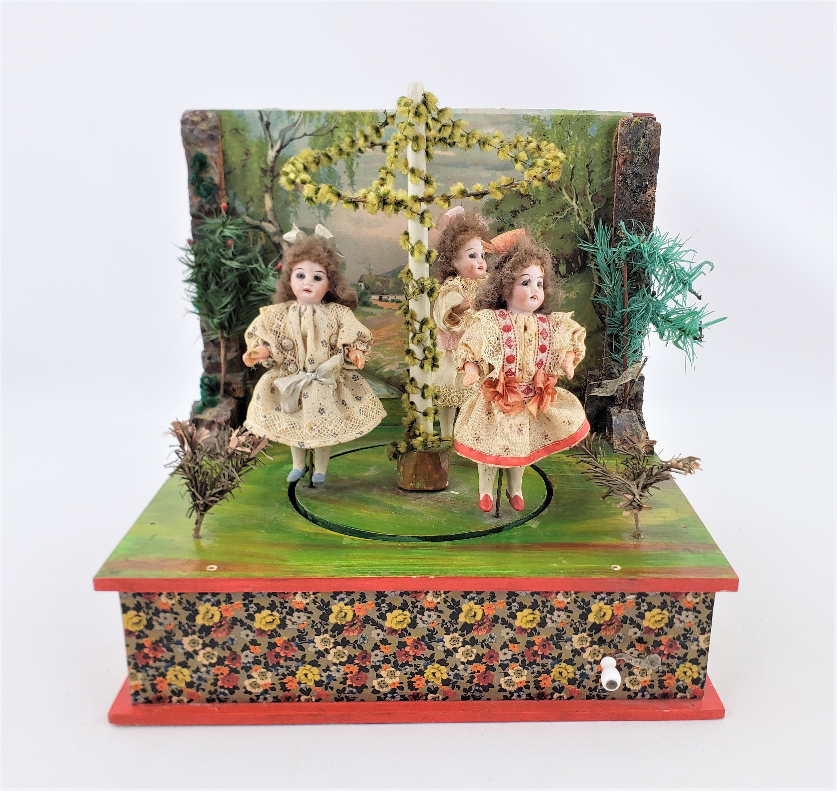 This antique mechanical toy music box shows no maker's signature, but is presumed to have been made in Germany in approximately 1900 in a period Bohemian style. The box is constructed of wood which has a hand-painted landscape on the back panel and