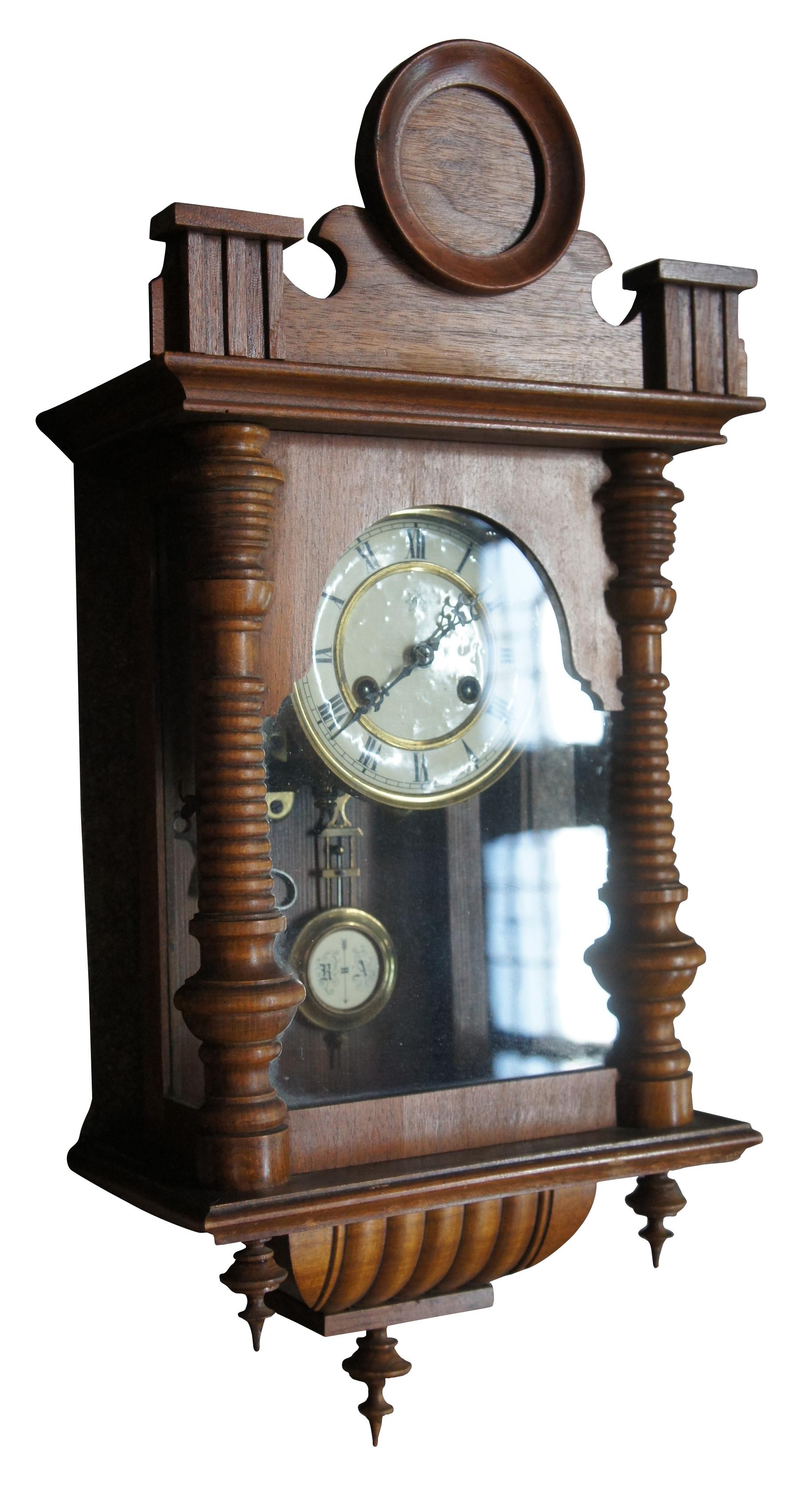 Antique German wall mounted Vienna Regulator clock by Junghans in a walnut case with ribbed / turned accents, drop finials, serpentine and circular crown and roman number face accented with brass.Good antique condition, wear and distressing