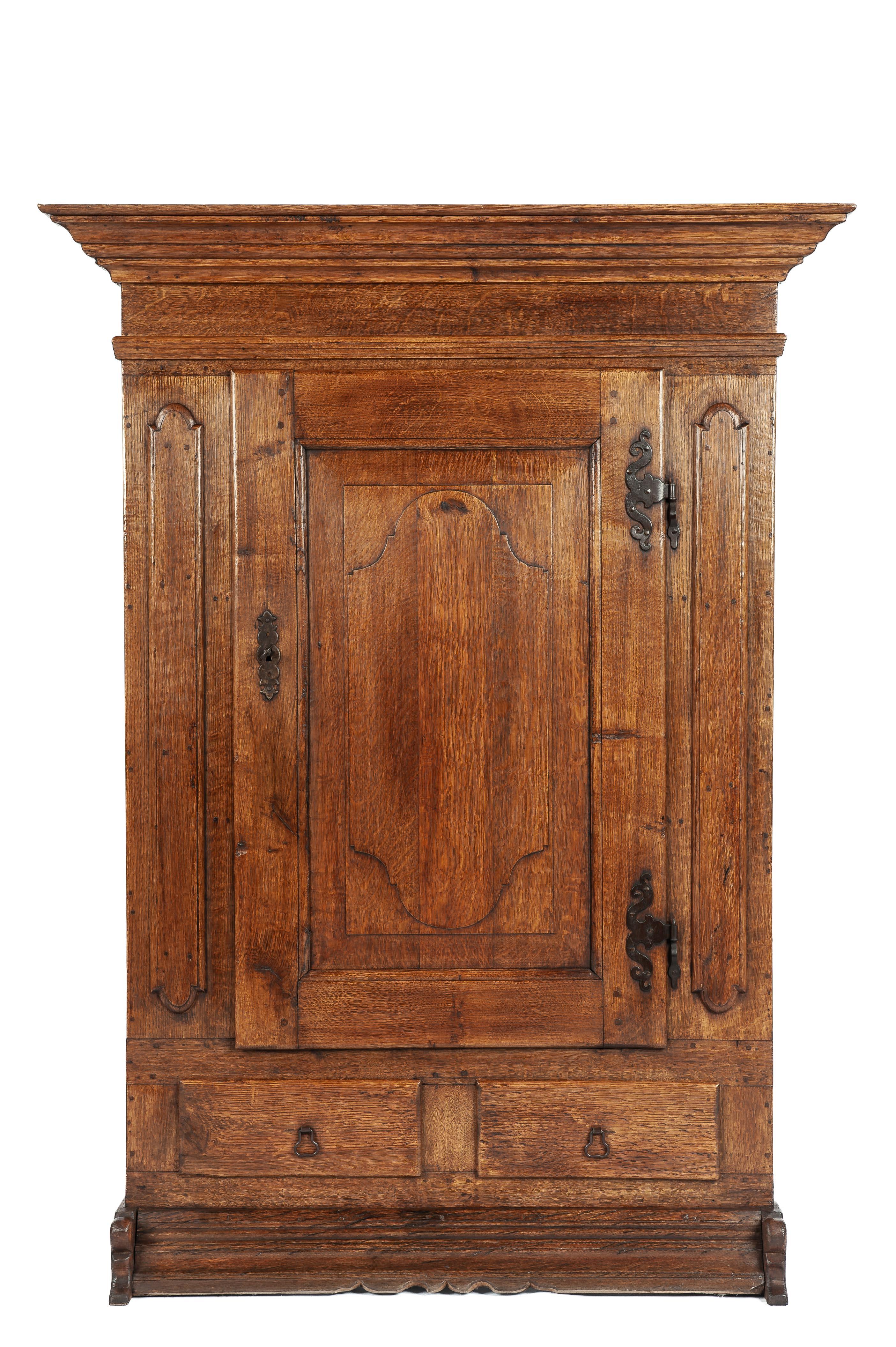 Nous vous proposons une magnifique armoire ancienne fabriquée en Allemagne vers 1900. Ce meuble est entièrement construit en bois de chêne massif et comporte une seule porte avec deux tiroirs en dessous. La porte est ornée d'un magnifique panneau en