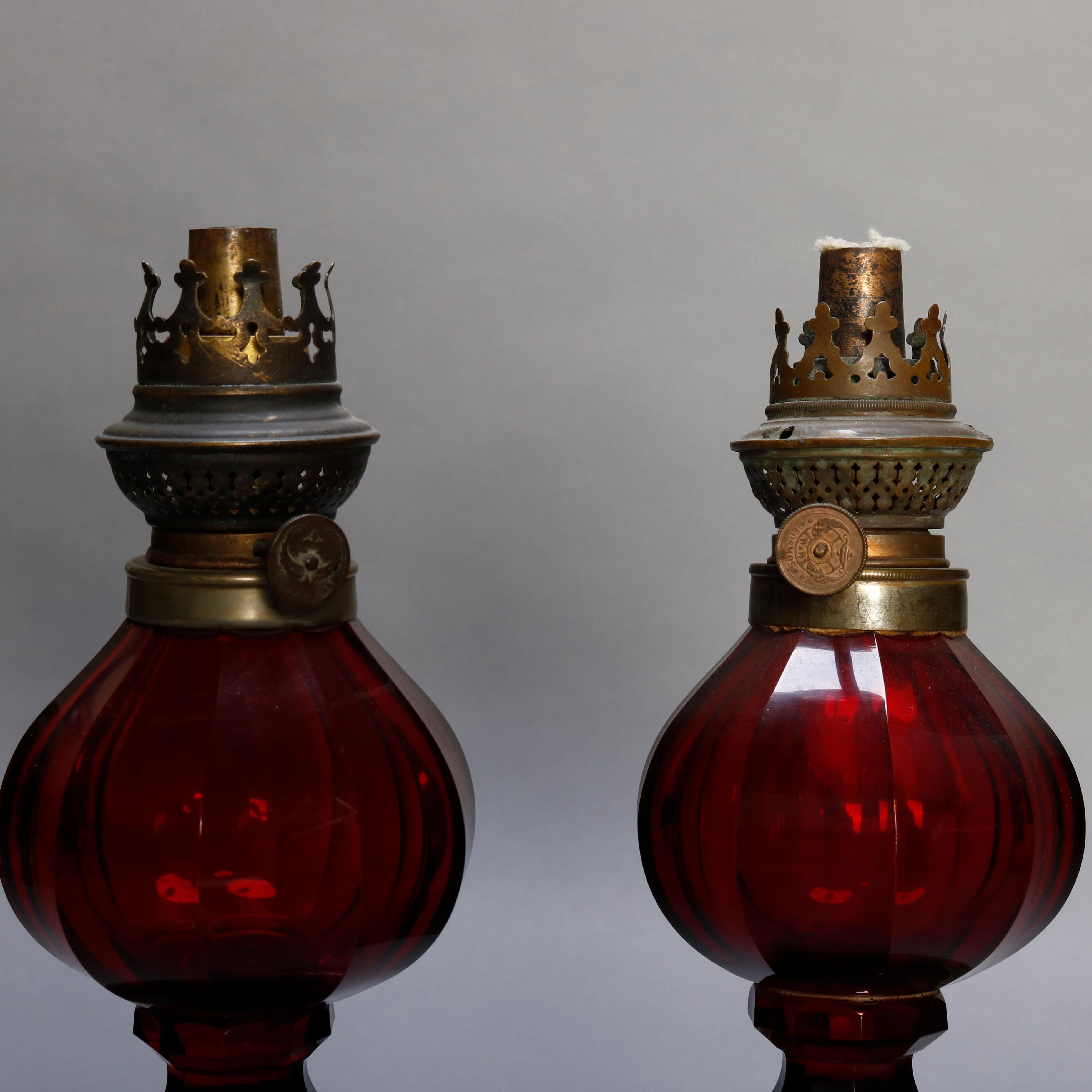 Pair of antique German kerosene lamps by Wild and Wessel offer faceted cranberry glass fonts raised on silver plate bases and having Kosmos burner, circa 1860.

Measures - 13.75” to wick, 5” diameter base, 9.25” chimney.
