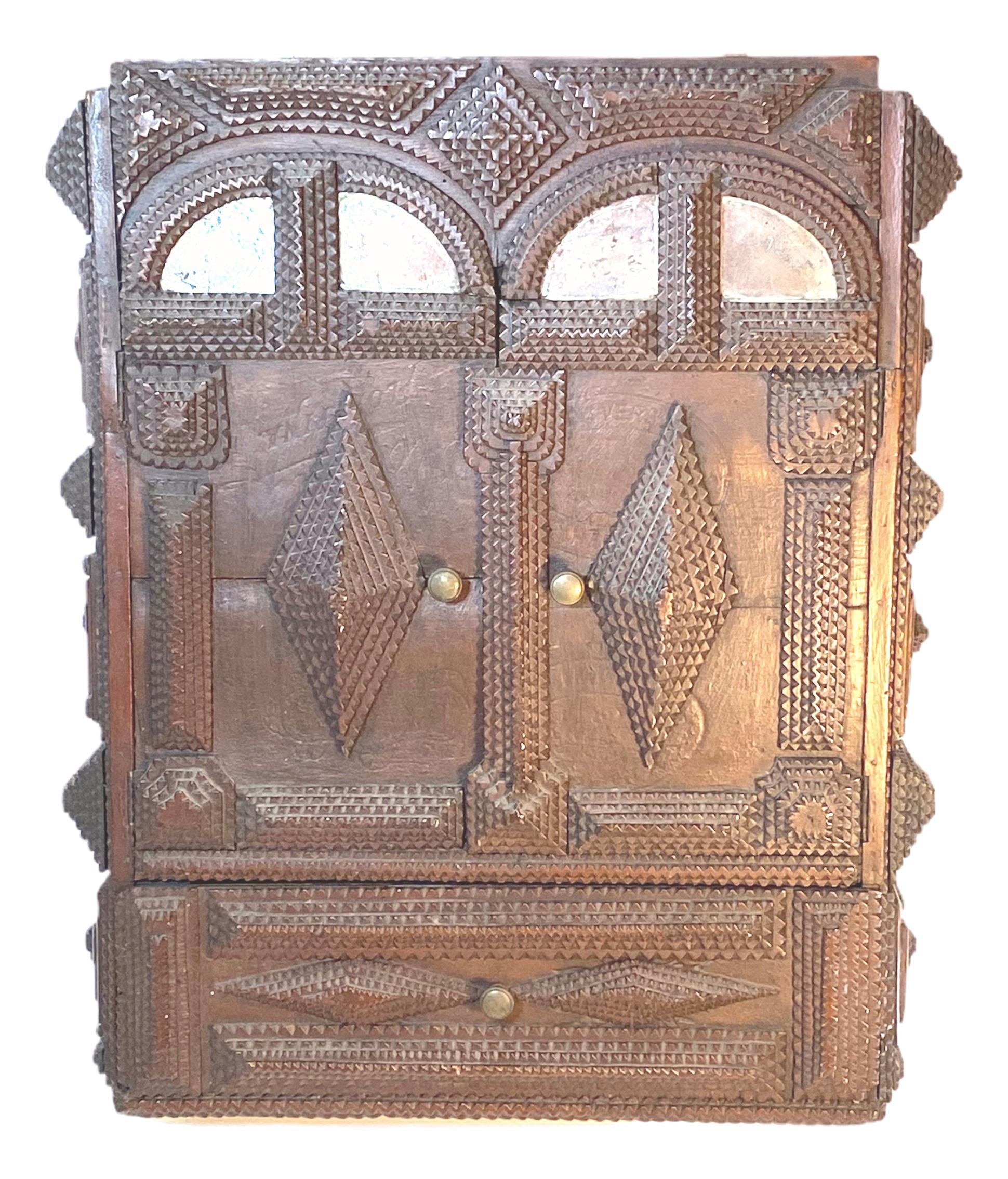 A petite German late 19th century Tramp Folk Art Wall Cupboard Cabinet. This petite Folk Art piece, circa 1880 comes from Germany and features a finely carved work with distressed Mirrors.
 It is a great example of the Tramp Art style, an art