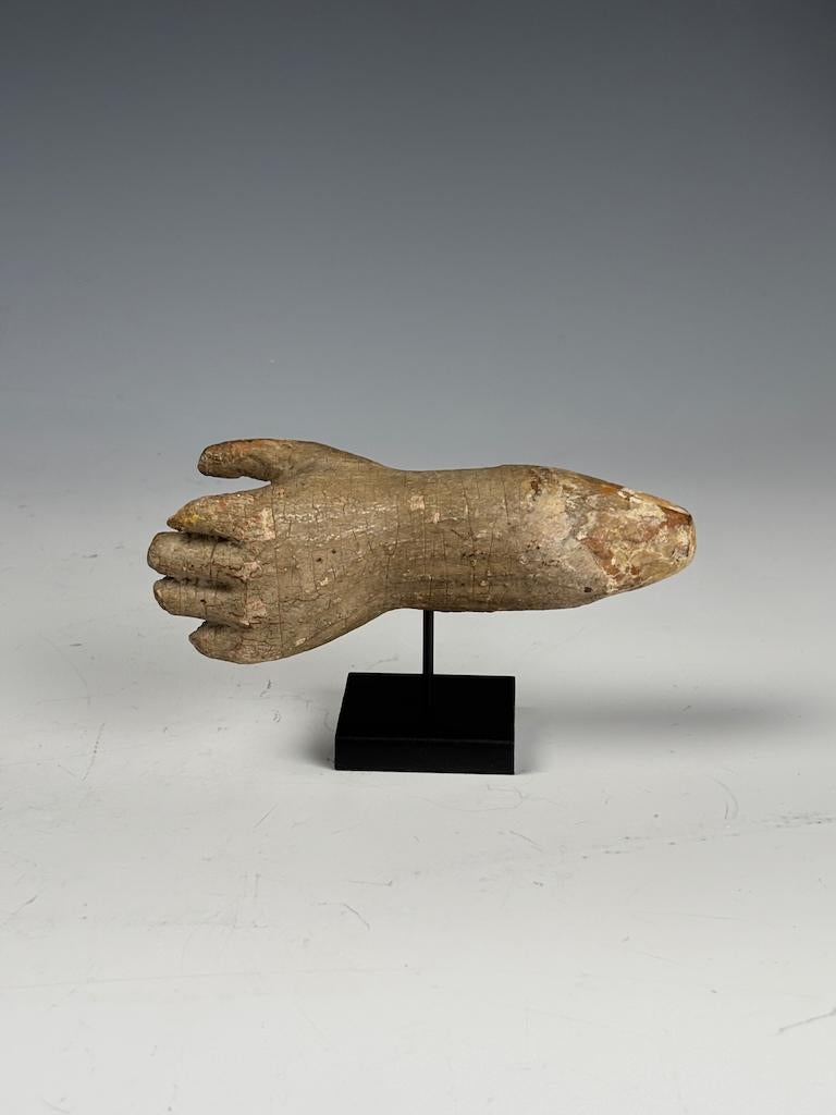 Antique Gesso-Painted Hand Fragment on Stand
Circa 18th–19th Century (possibly earlier)

This evocative sculptural fragment represents a small gesso-painted hand, likely once part of a larger devotional or religious figure. Expertly carved from wood