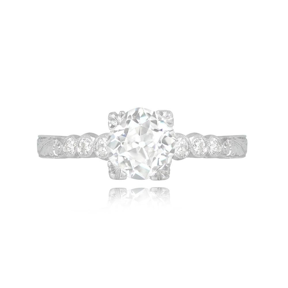 This Art Deco engagement ring showcases a GIA-certified 1.01-carat old European cut diamond, with K color and VVS2 clarity, securely held in prongs. The ring's shoulders are adorned with smaller bezel-set diamonds, totaling about 0.12 carats. Its