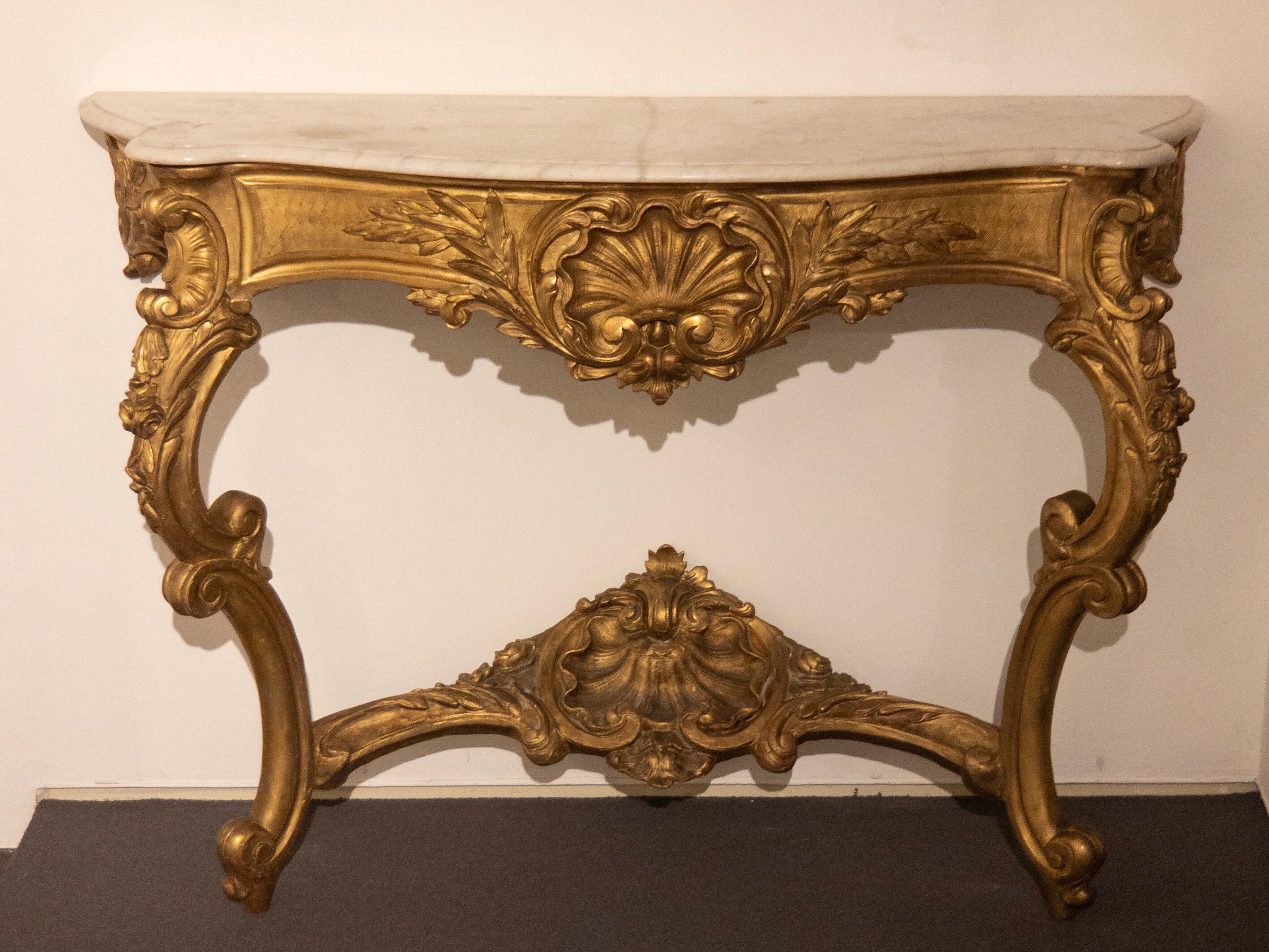 Wonderful antique Baroque console table from the late 18th or early 19th century. The gilded console table was manufactured in France and has a white/grey grained marble top. 

Dimensions:
W 53.937 in. / D 17.717 in. / H 38.583 in. 
W 137 cm / D