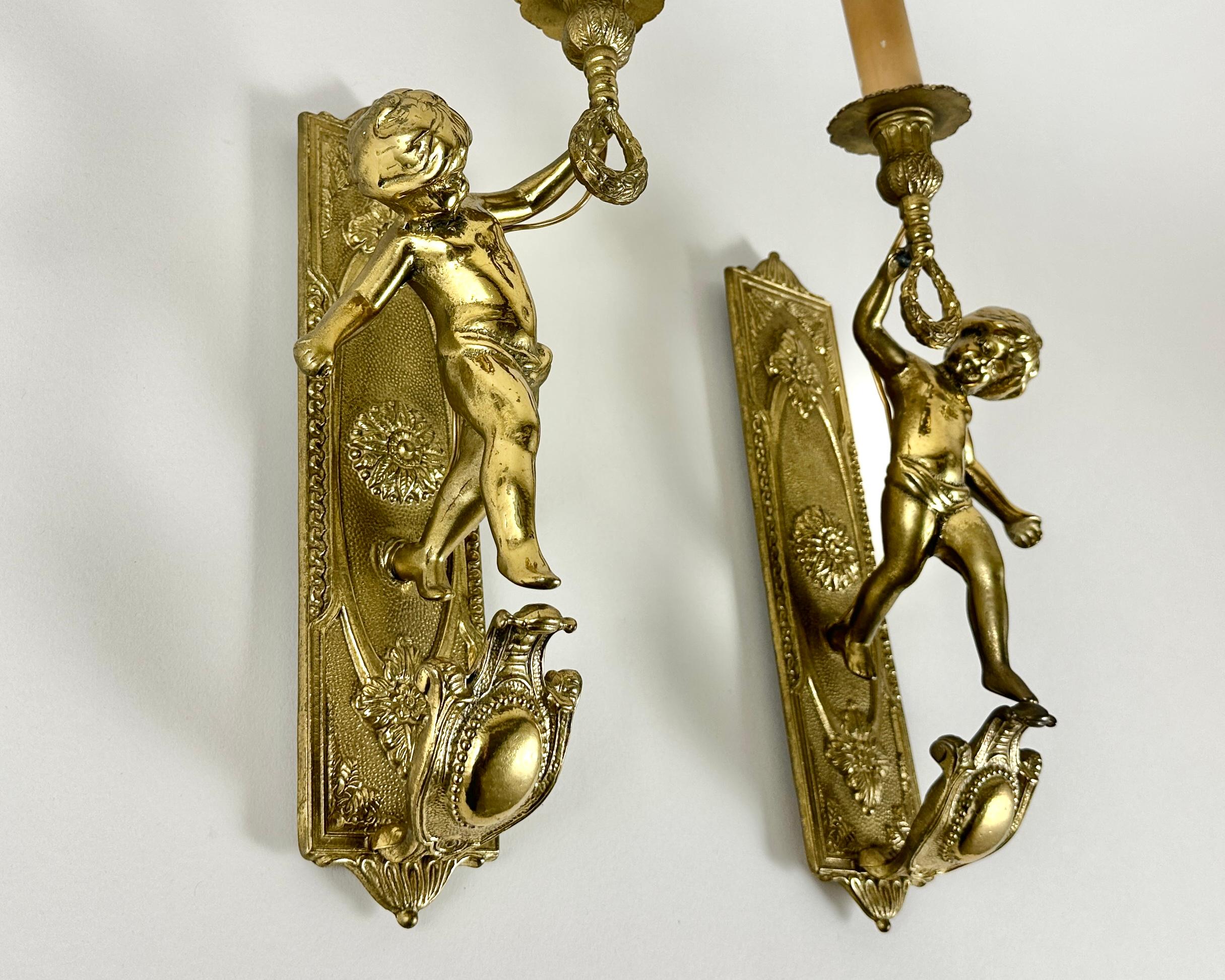 Antique Gilded Bronze Angel Wall Sconces from France, 1920s

Magnificent pair of antique angel wall sconces, crafted from beautifully gilded bronze. Originating from an era where artistry and craftsmanship reigned supreme, these sconces are more