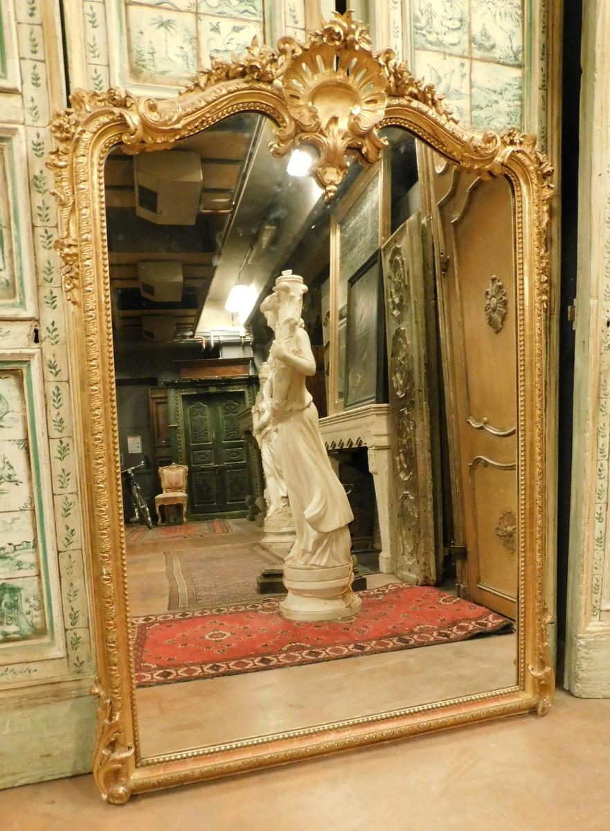 Antique gilded mirror, with hand-carved wooden frame with shell and frills, hand-built in the late 19th century, in Italy.
Given its size it can be placed both on the ground and on a piece of furniture or fireplace, very beautiful, it gives light