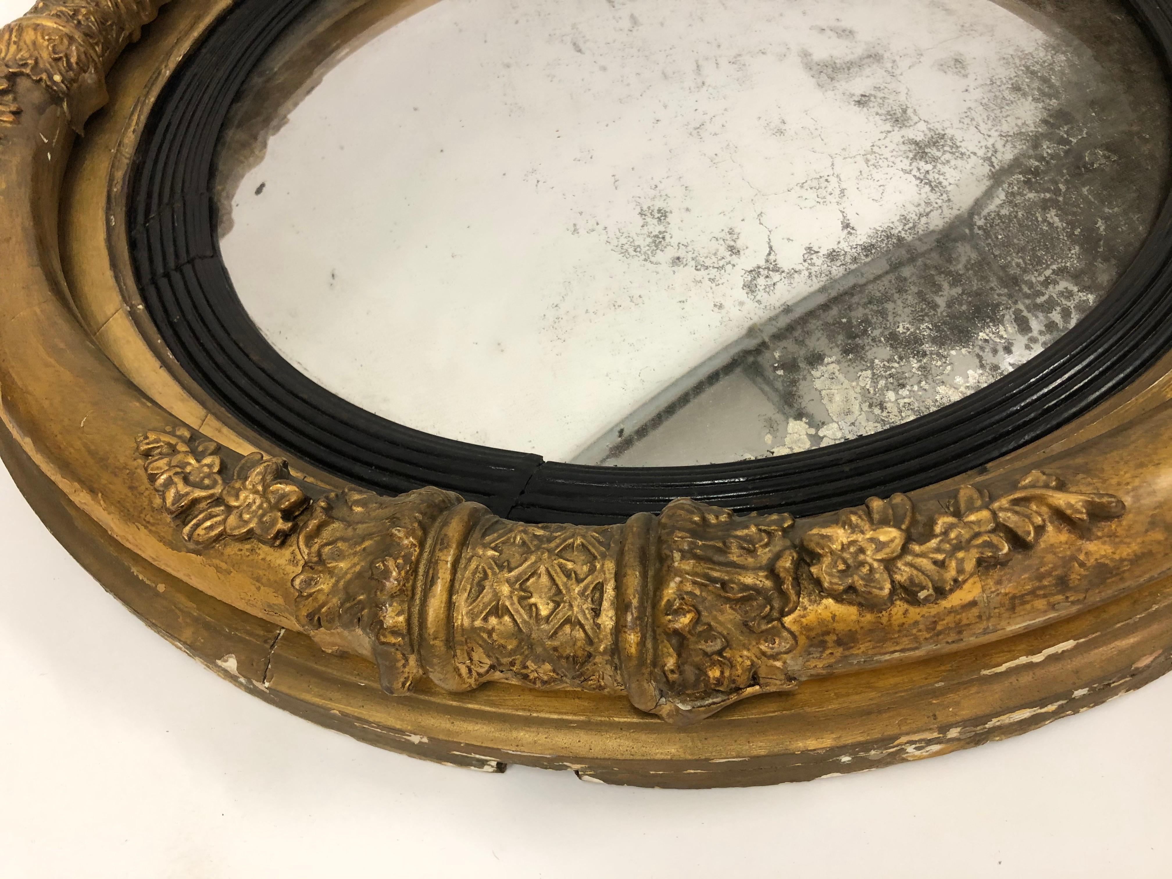 Espejo antiguo dorado con tallas decorativas. El diámetro es de 25