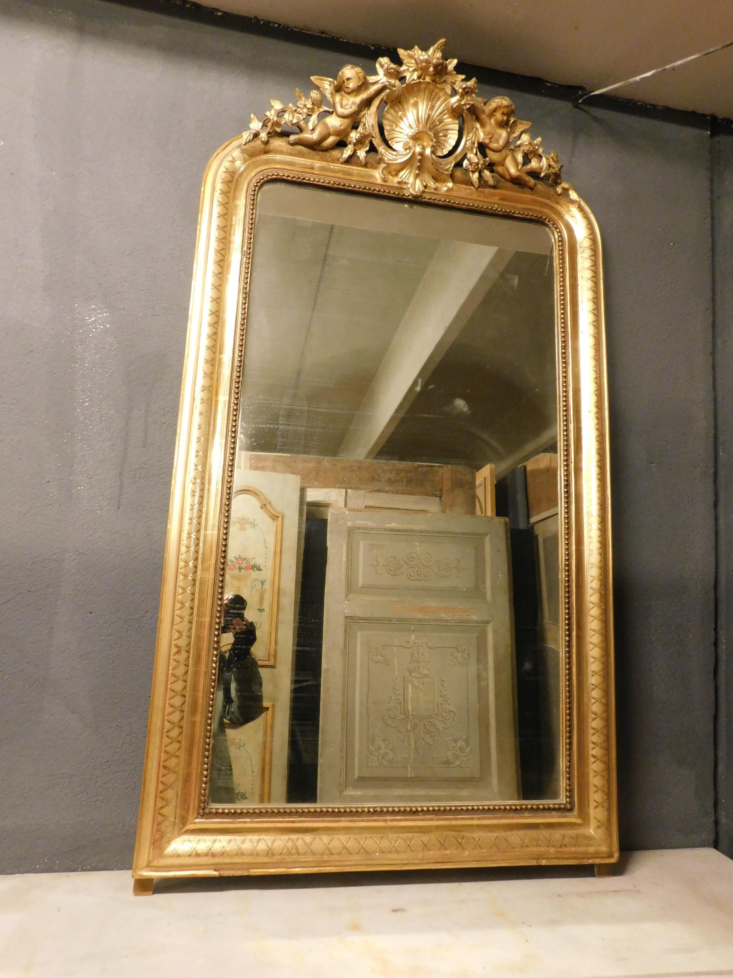Ancient gilded wooden mirror with cherubs and hand carved shell, gilded with precious leaf, with engravings on the frame and richly carved molding.
From the 19th century, built in Italy, measuring 86 x 86 cm (including 4 cm wooden feet), maximum