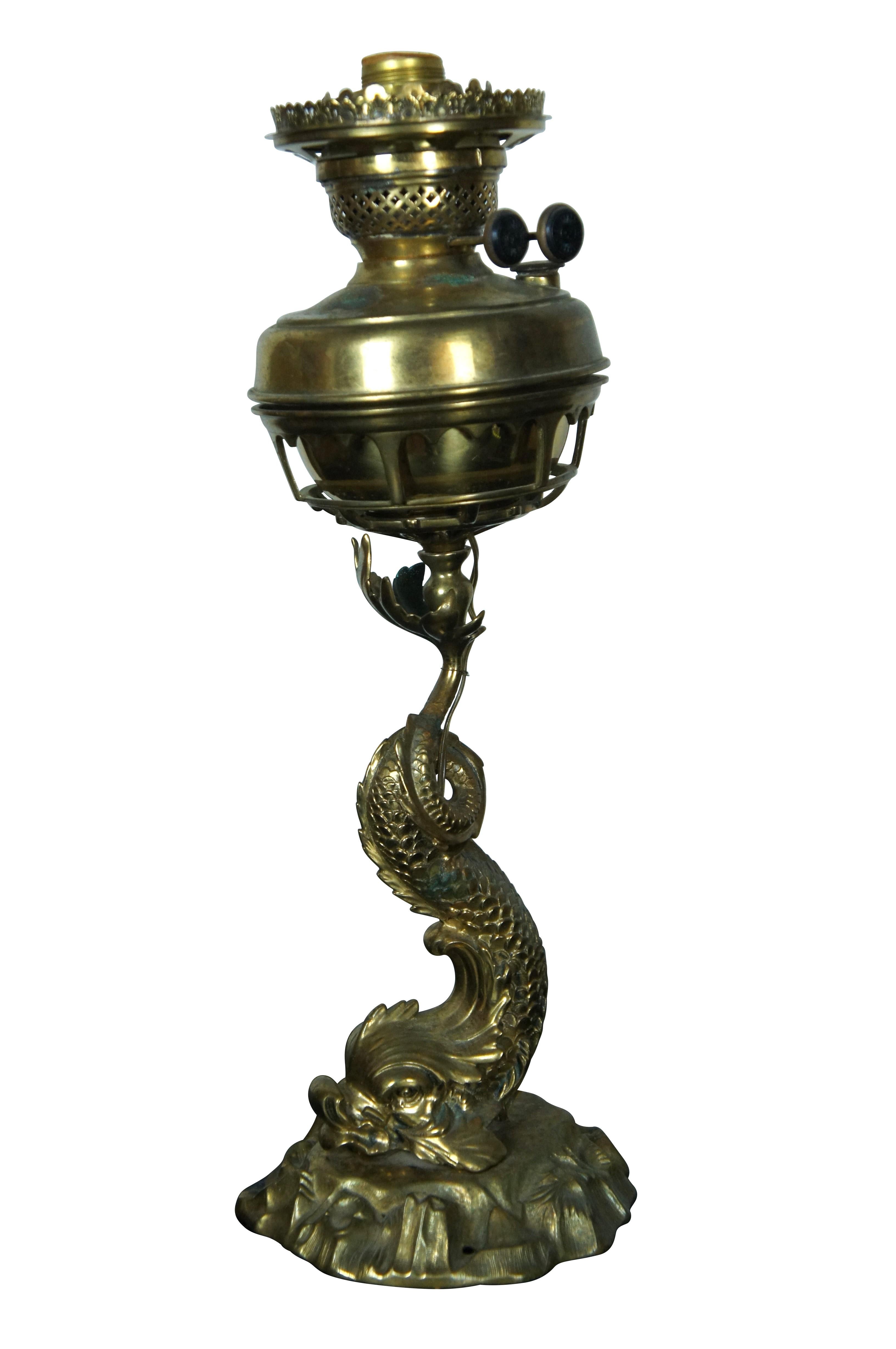 Late 19th century gilt brass converted oil lamp or lantern, featuring a Neoclassical delphin / dolphin on a base of rocks, balancing the oil reservoir on its tail. Sun with face mark on burner knobs.

Dimensions:
6.5