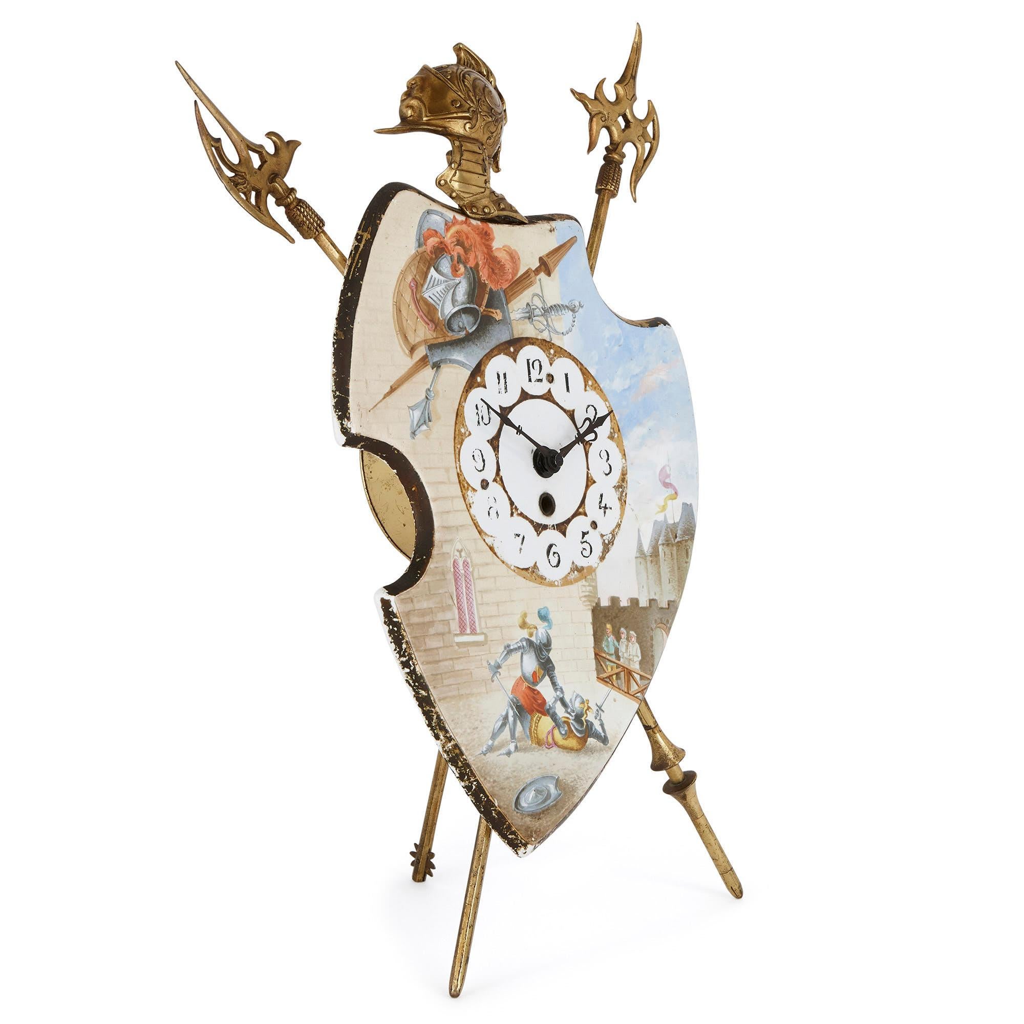 This beautiful porcelain mantel clock is designed in the shape of a shield which is propped up on a gilt bronze (ormolu) easel support, composed of two shields and a staff topped by a helmet. The porcelain shield is painted, in the upper left