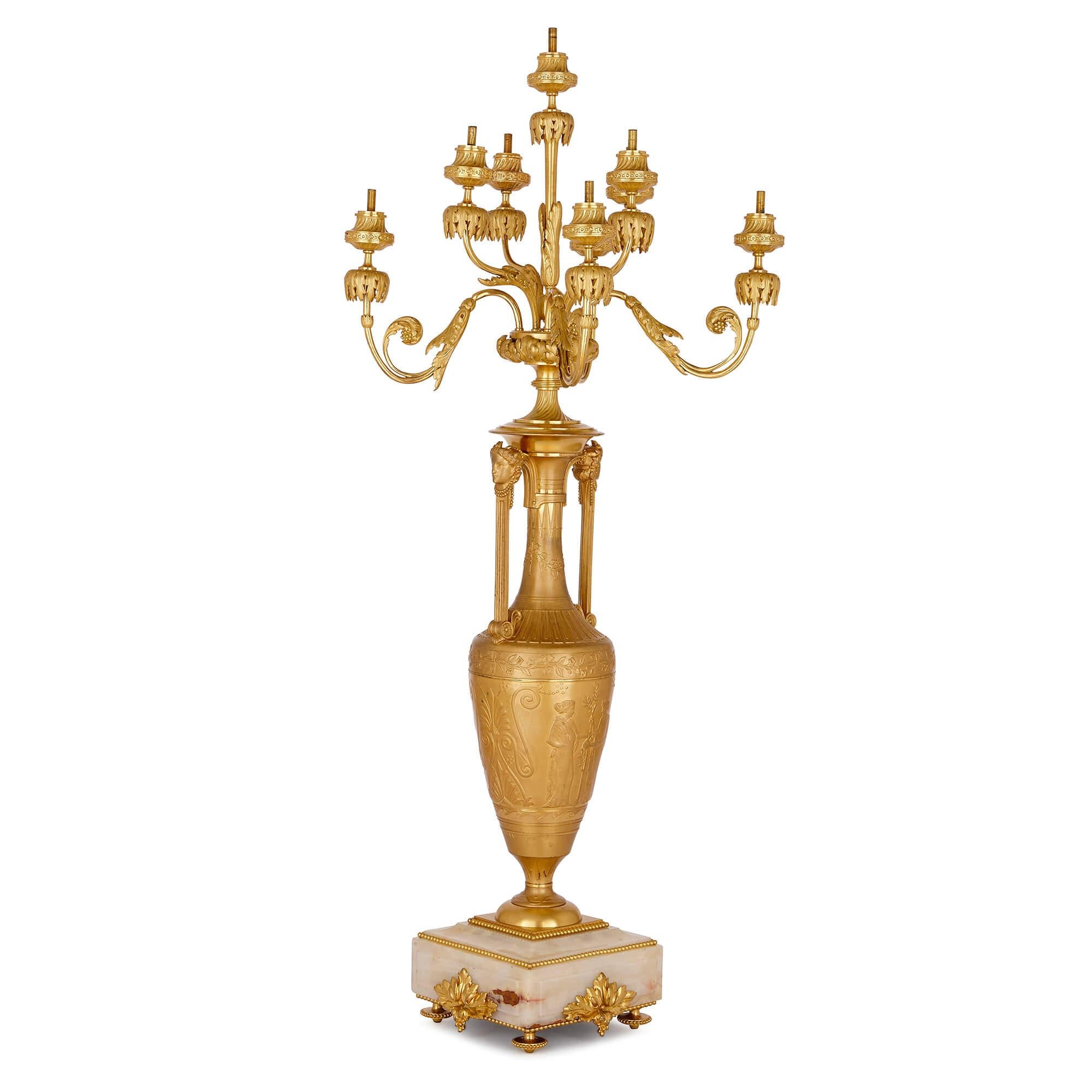 Mounted on an onyx base, this Grecian style gilt bronze candelabrum is of vase form, which is topped by twelve lights. The piece is signed ‘F. Barbedienne, Fondeur' and 'Henry Cahieux’. 

Head decorator at the Barbedienne bronze foundry, Cahieux